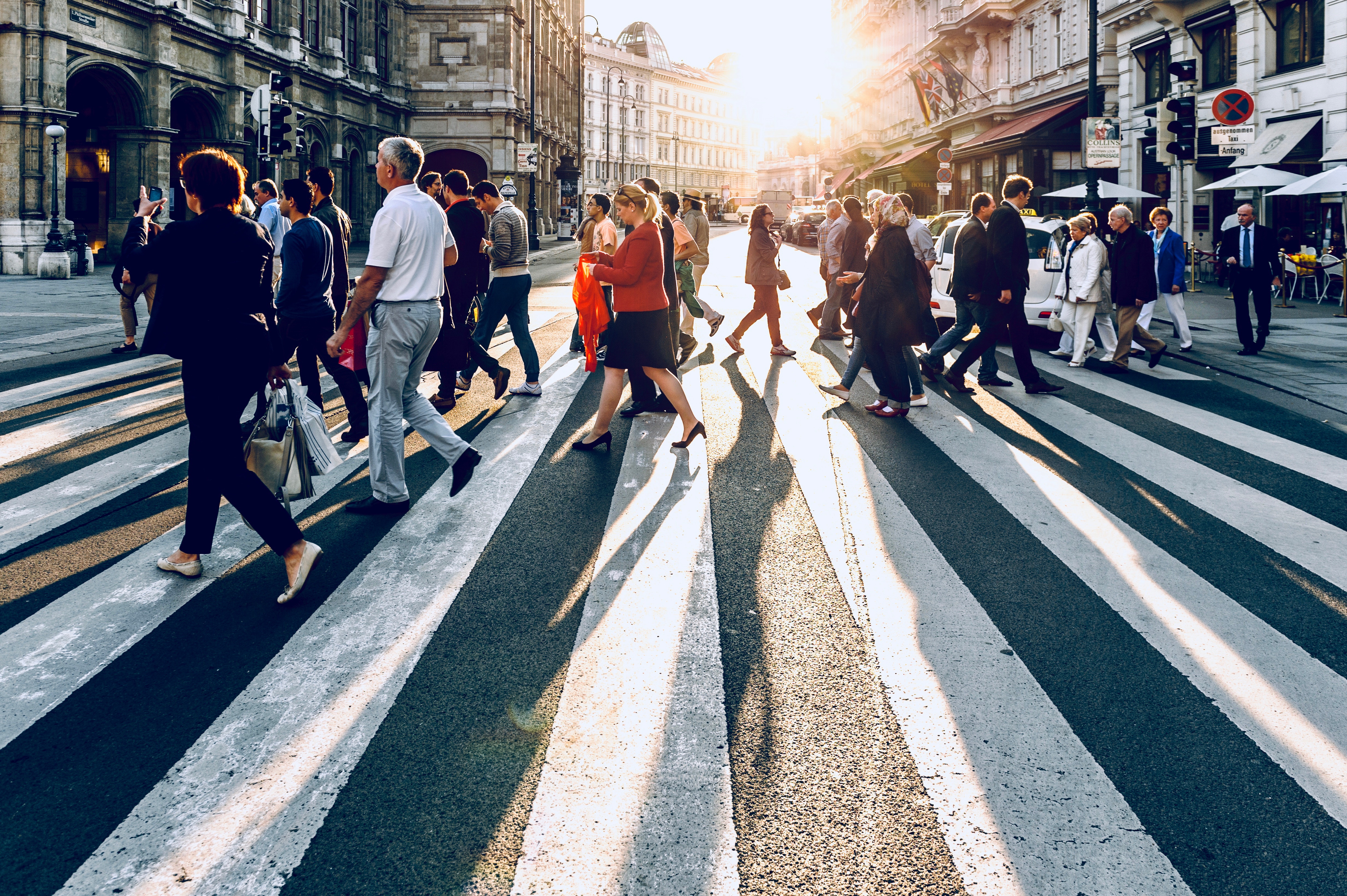 People crossing a street in Vienna at sunset HD Wallpaper