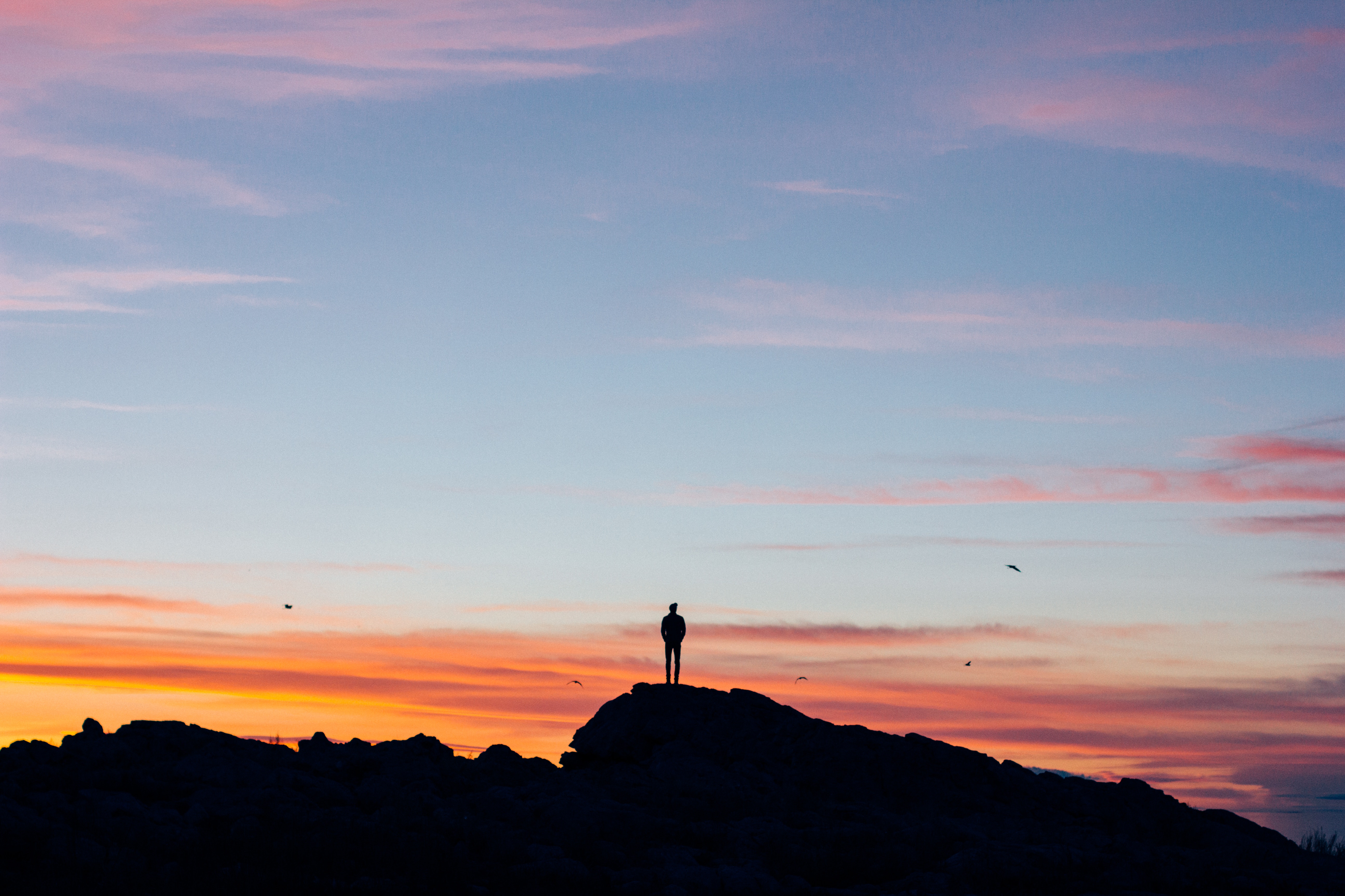 Silhouette of a person on a hill at sunset HD Wallpaper