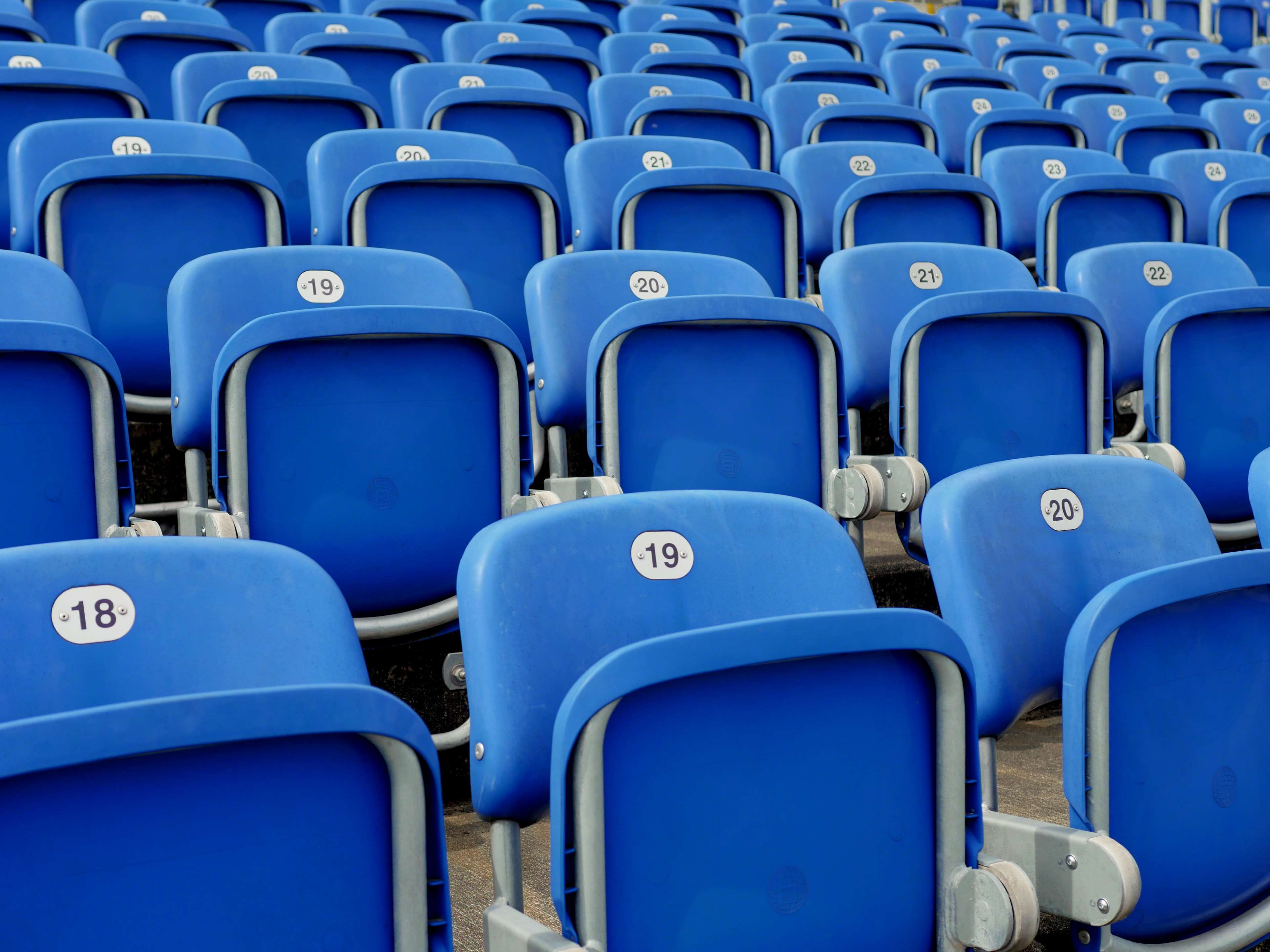 Rows of empty blue stadium seats with numbers HD Wallpaper