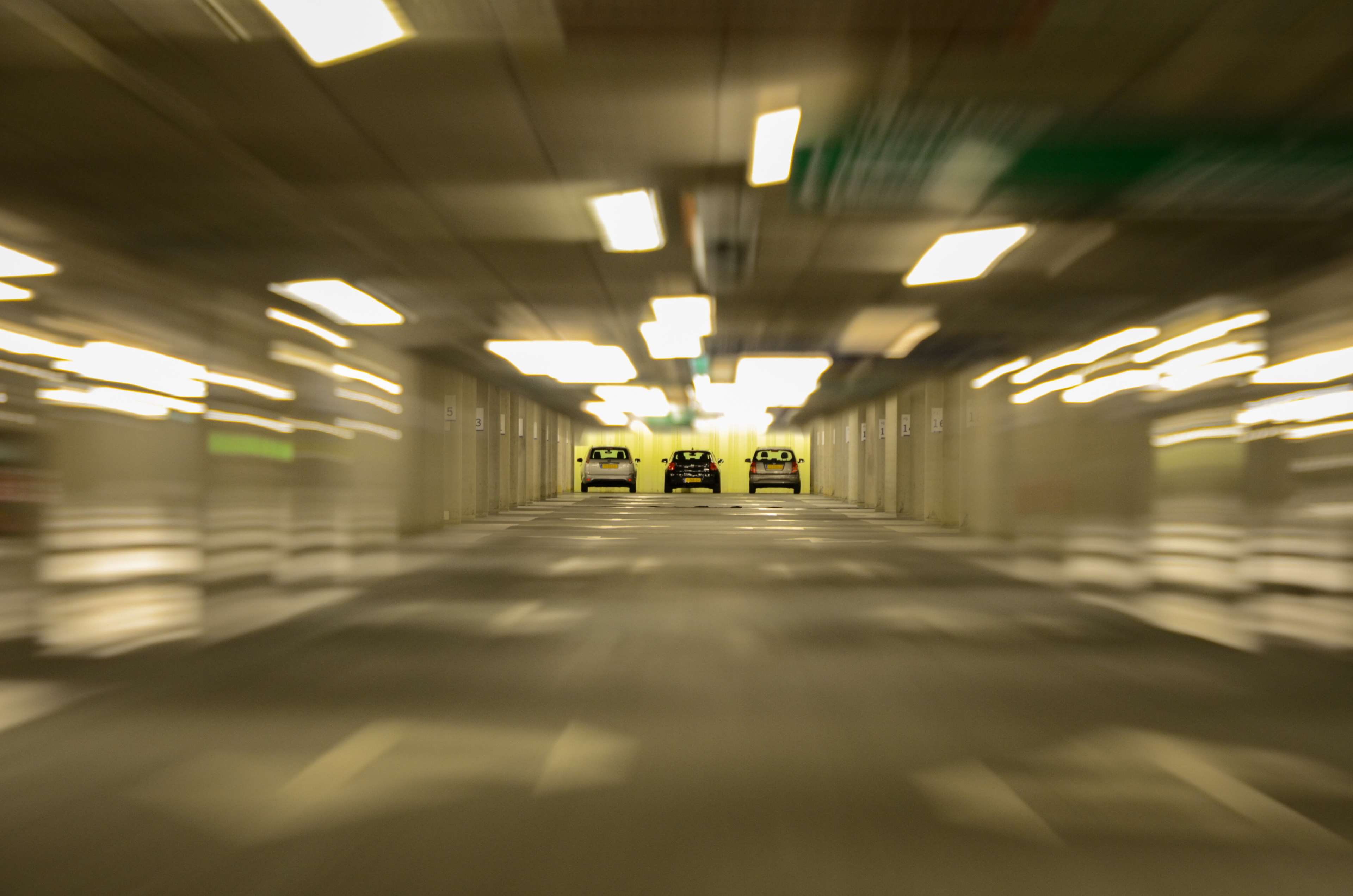 Cars in a blurry underground parking lot HD Wallpaper