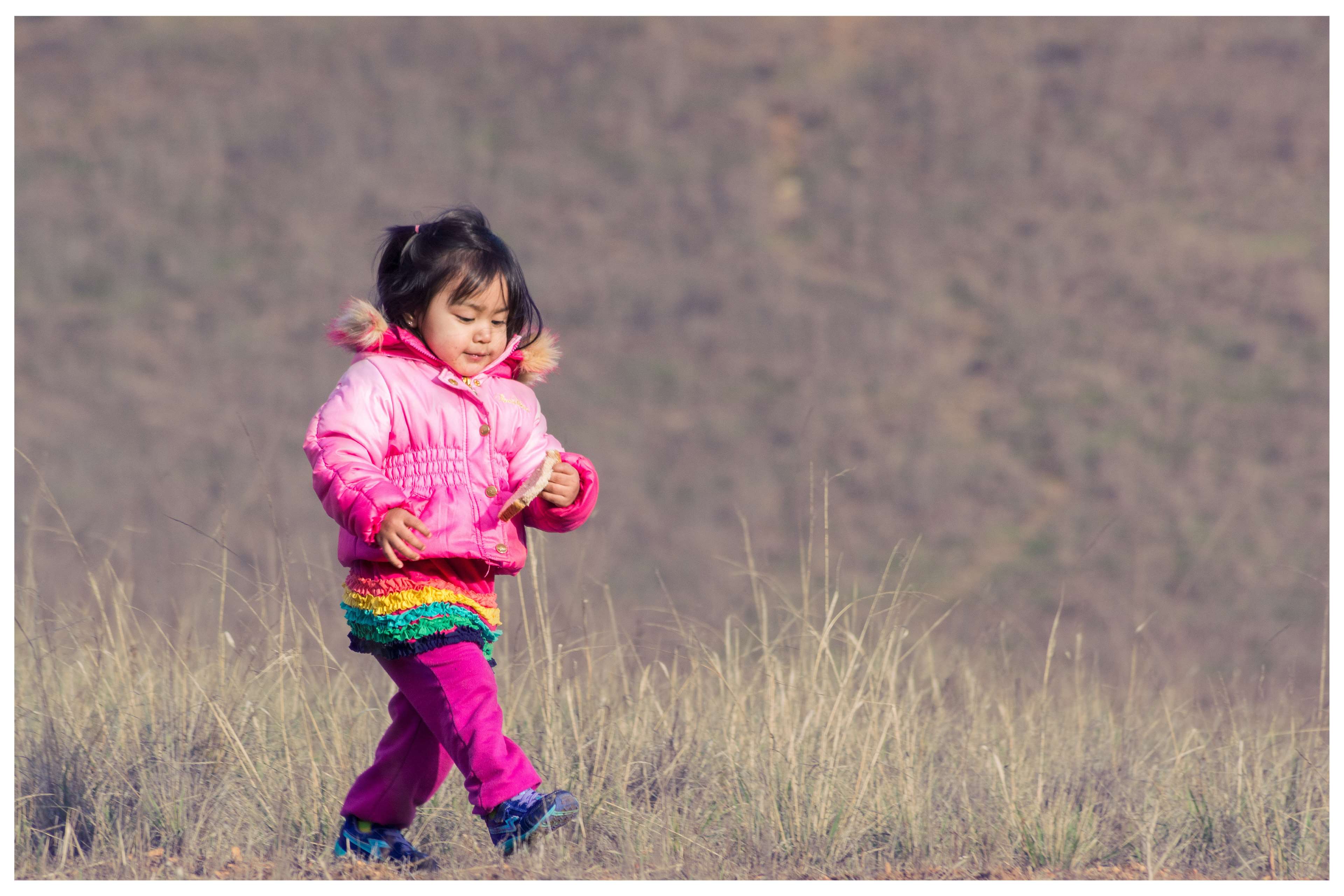 Young girl in pink jacket walking in nature 4K HD Wallpaper