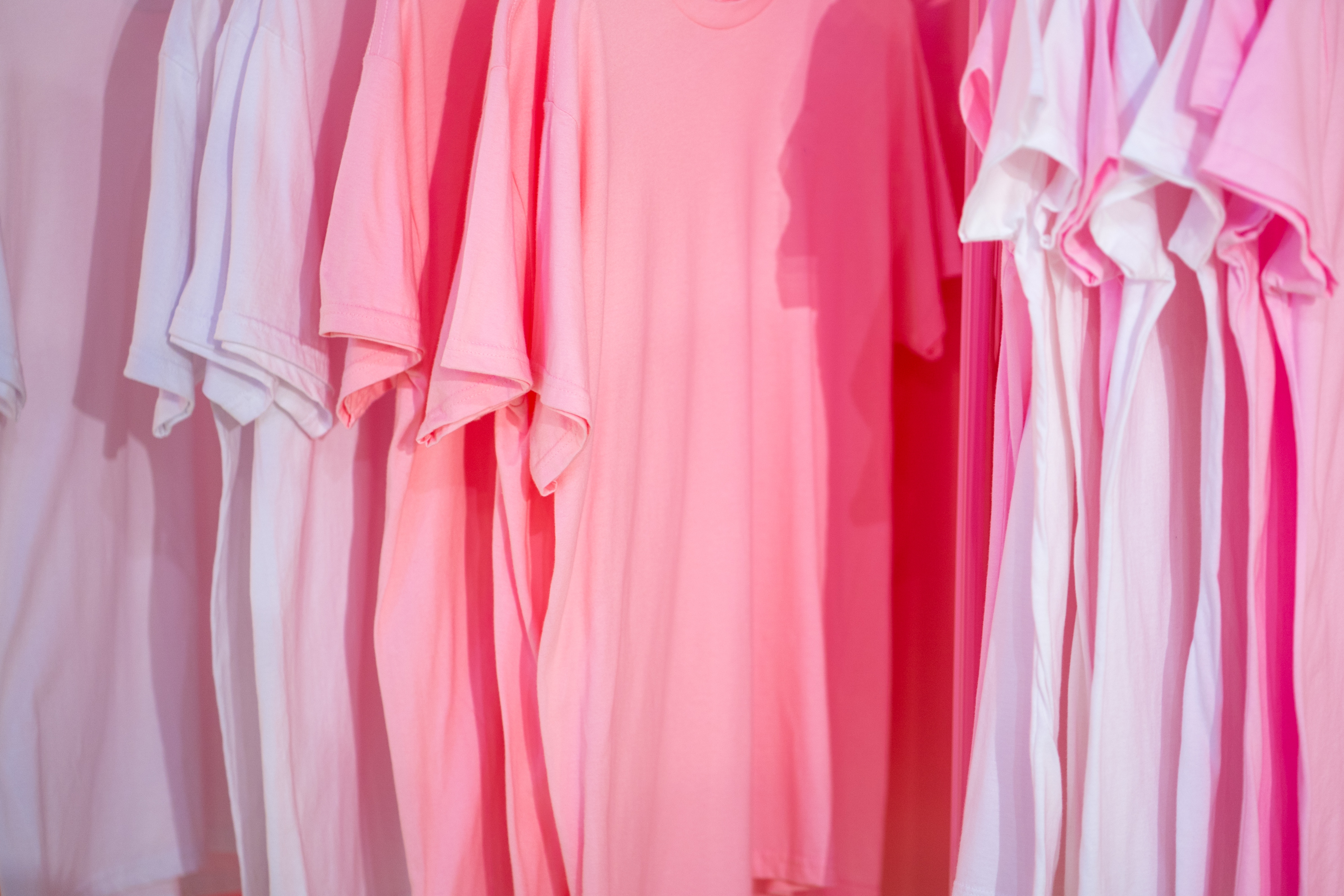 Pink and white t-shirts hanging on a rack HD Wallpaper