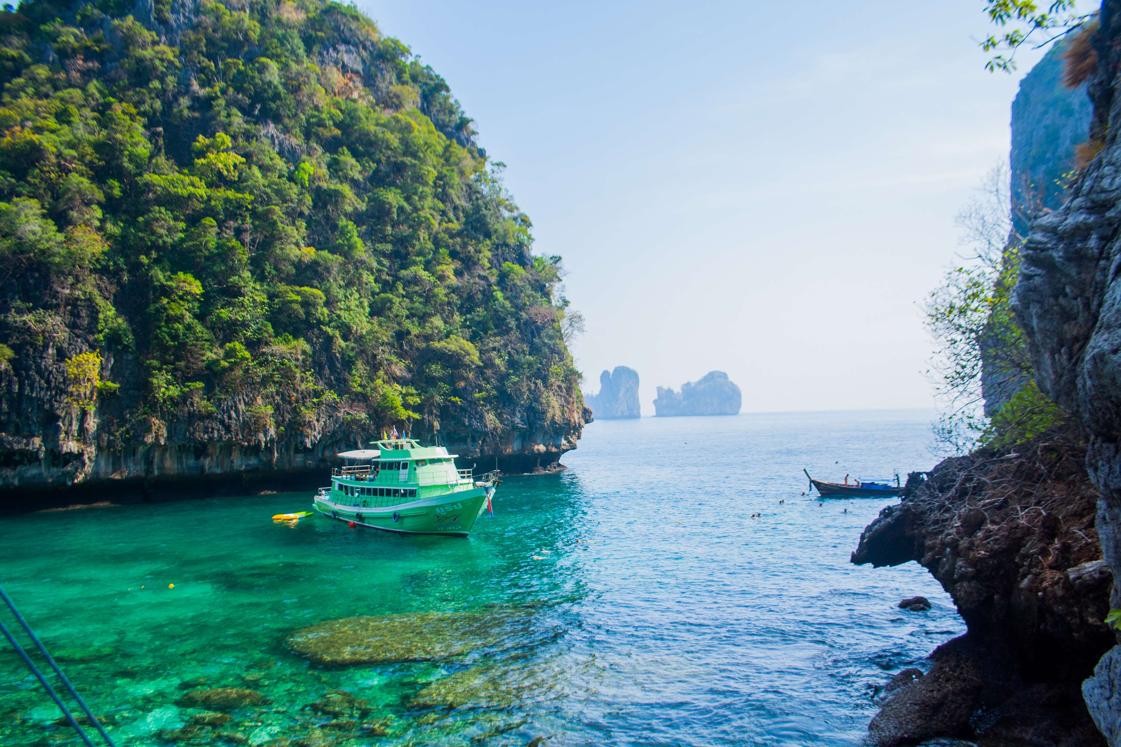 Green boat in a tropical bay with limestone cliffs HD Wallpaper