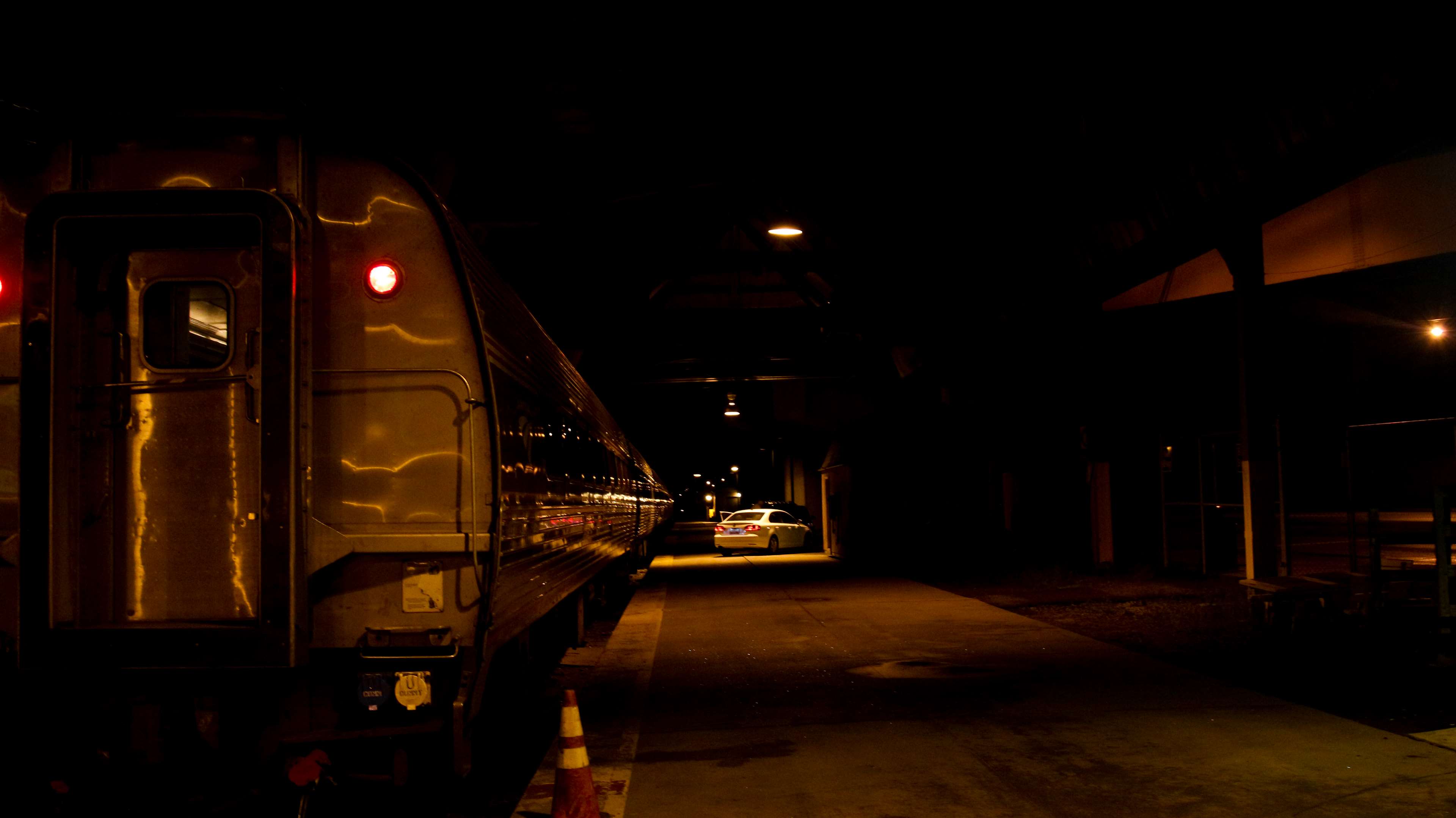 Train at a dark train station at night HD Wallpaper