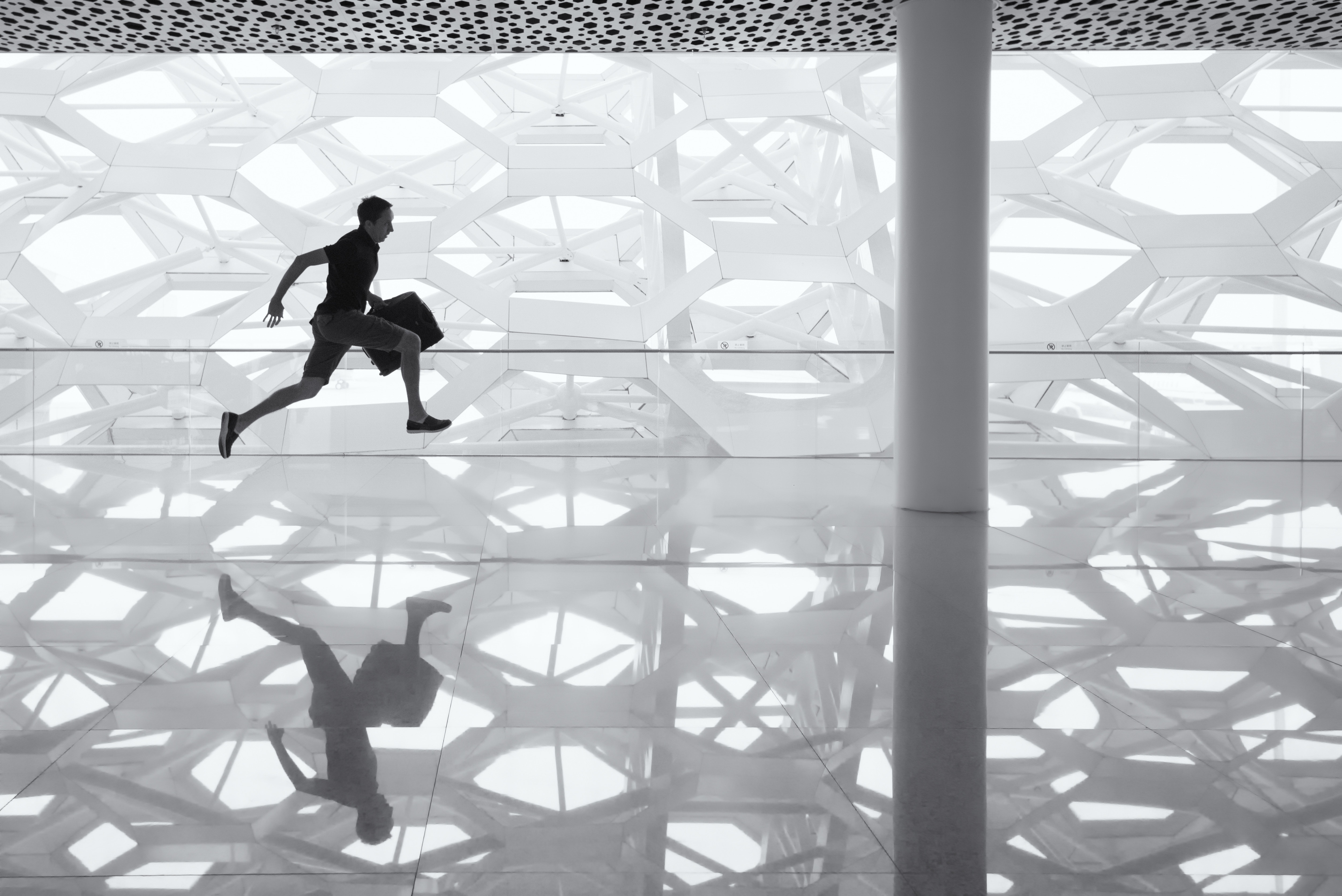 Man running with luggage in modern architecture HD Wallpaper