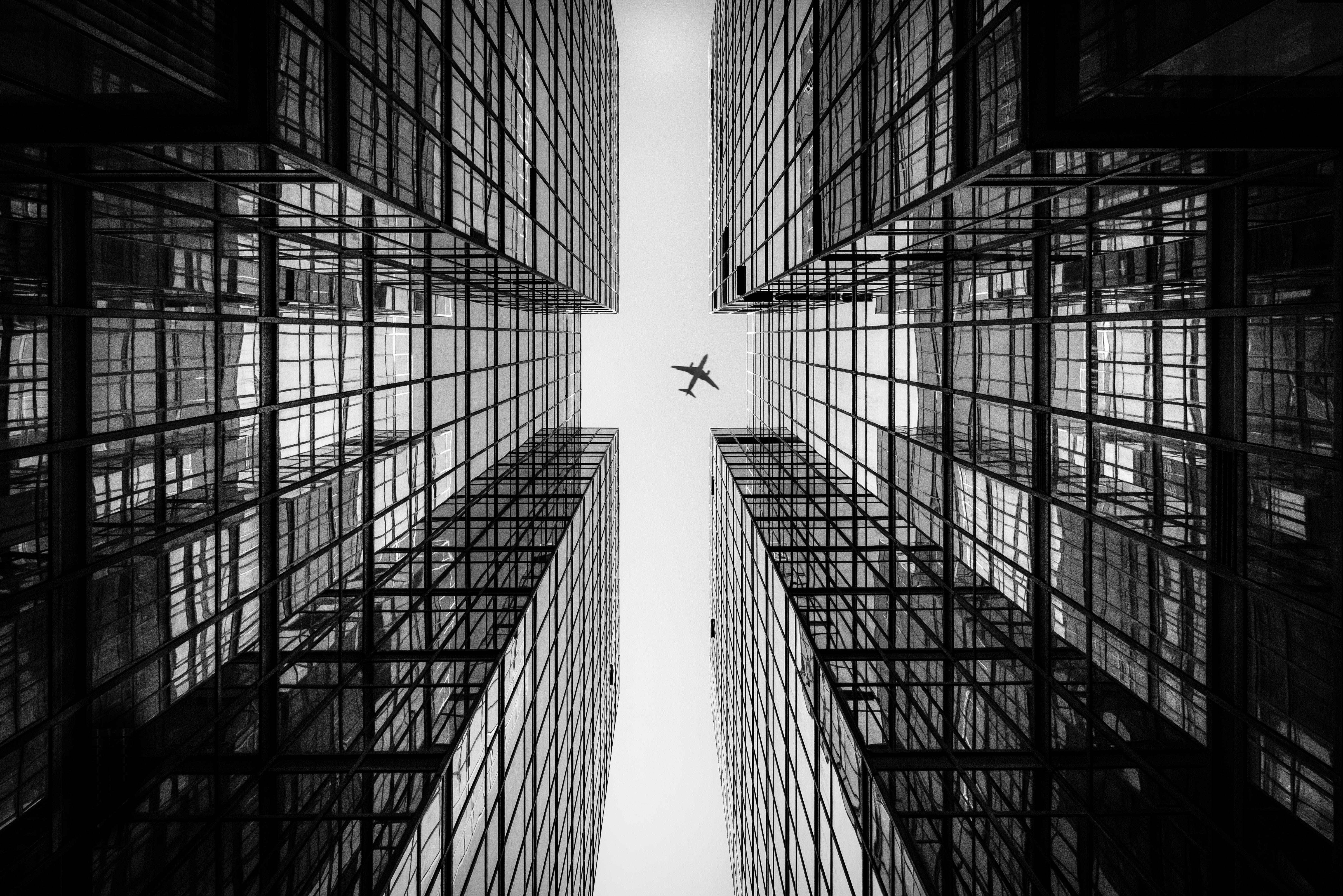 Airplane flying between Hong Kong skyscrapers HD Wallpaper