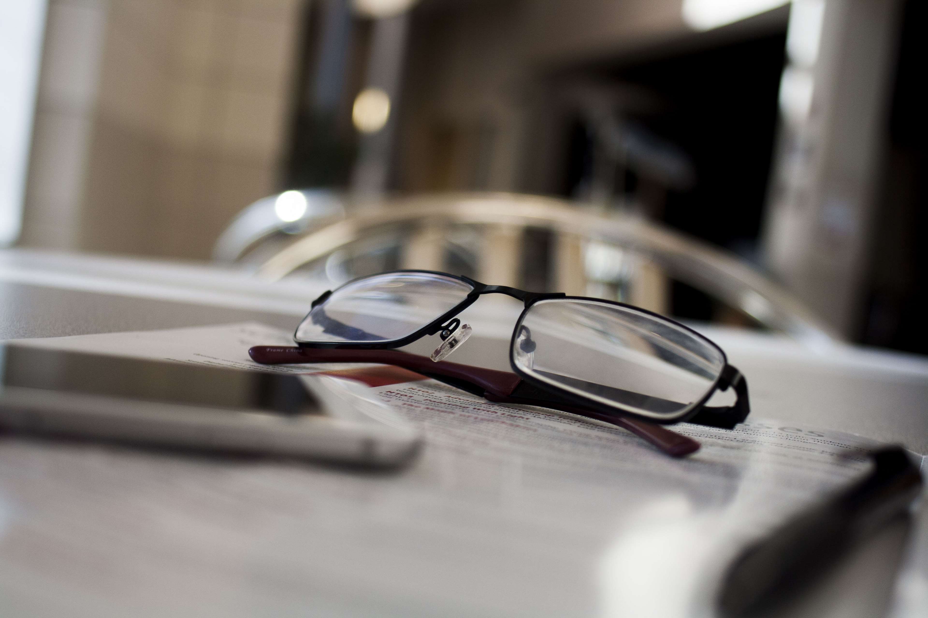 Glasses on a table with a phone and papers HD Wallpaper