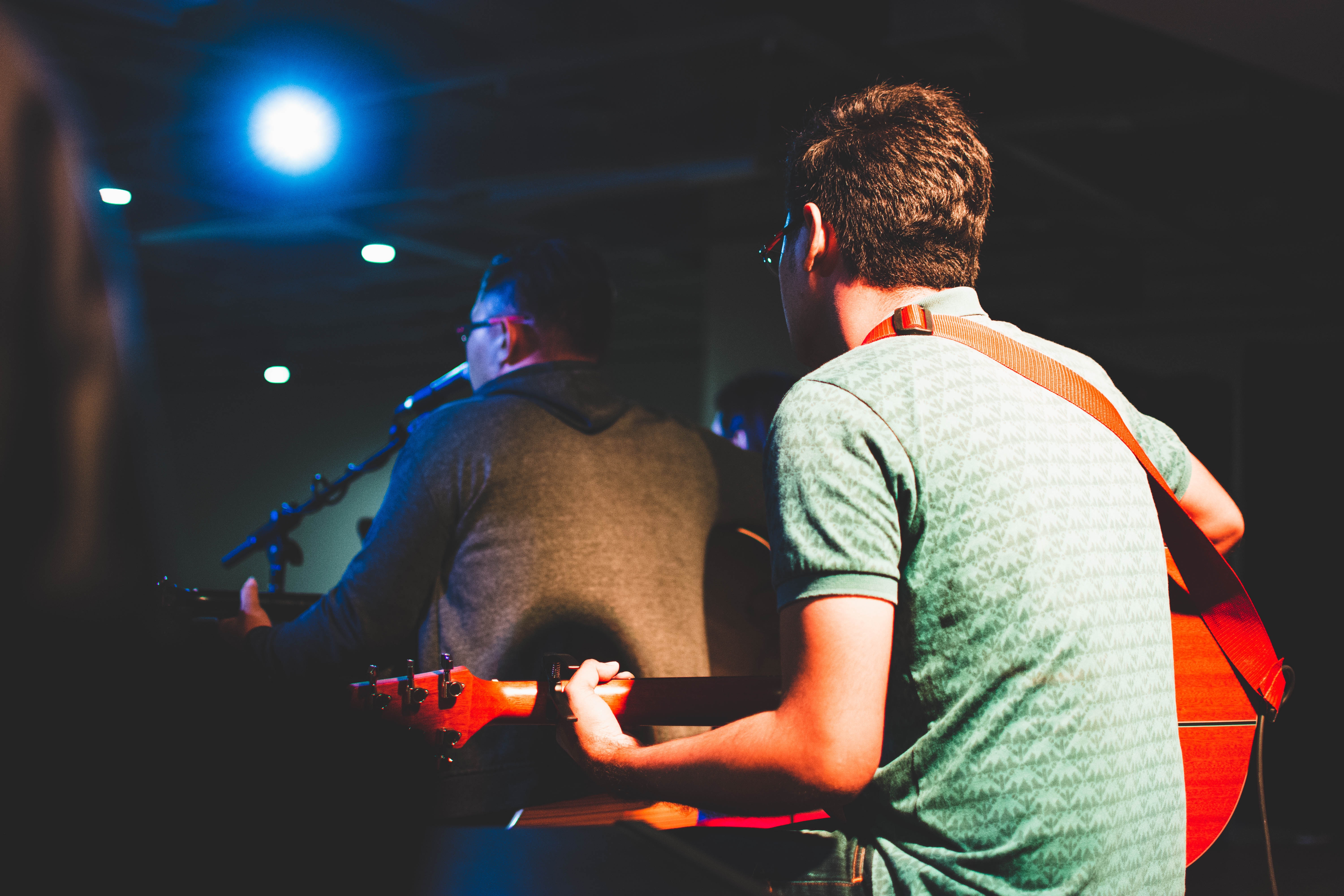 Men playing guitars on stage with spotlight HD Wallpaper
