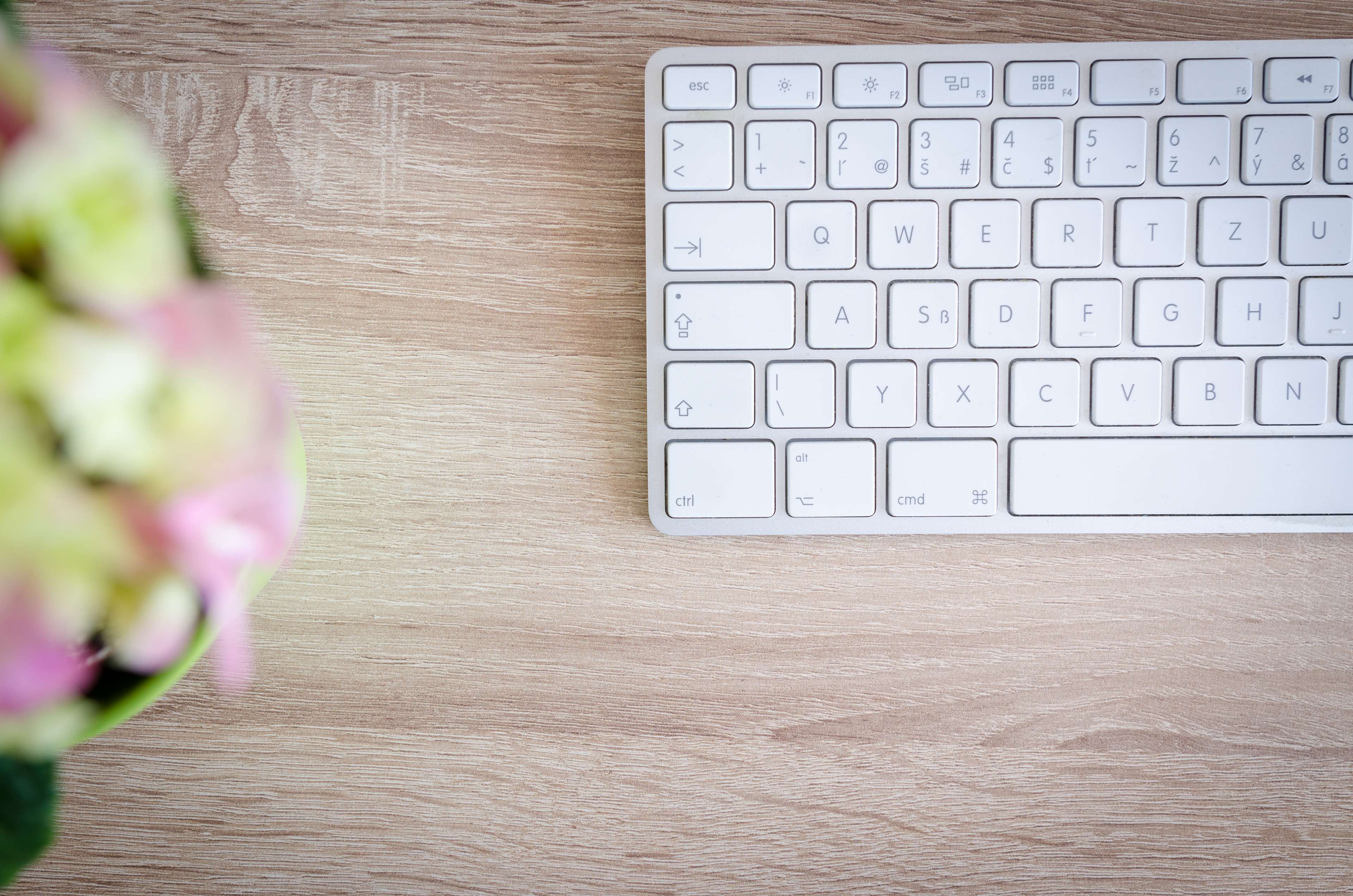 White keyboard on a wooden table with flowers HD Wallpaper