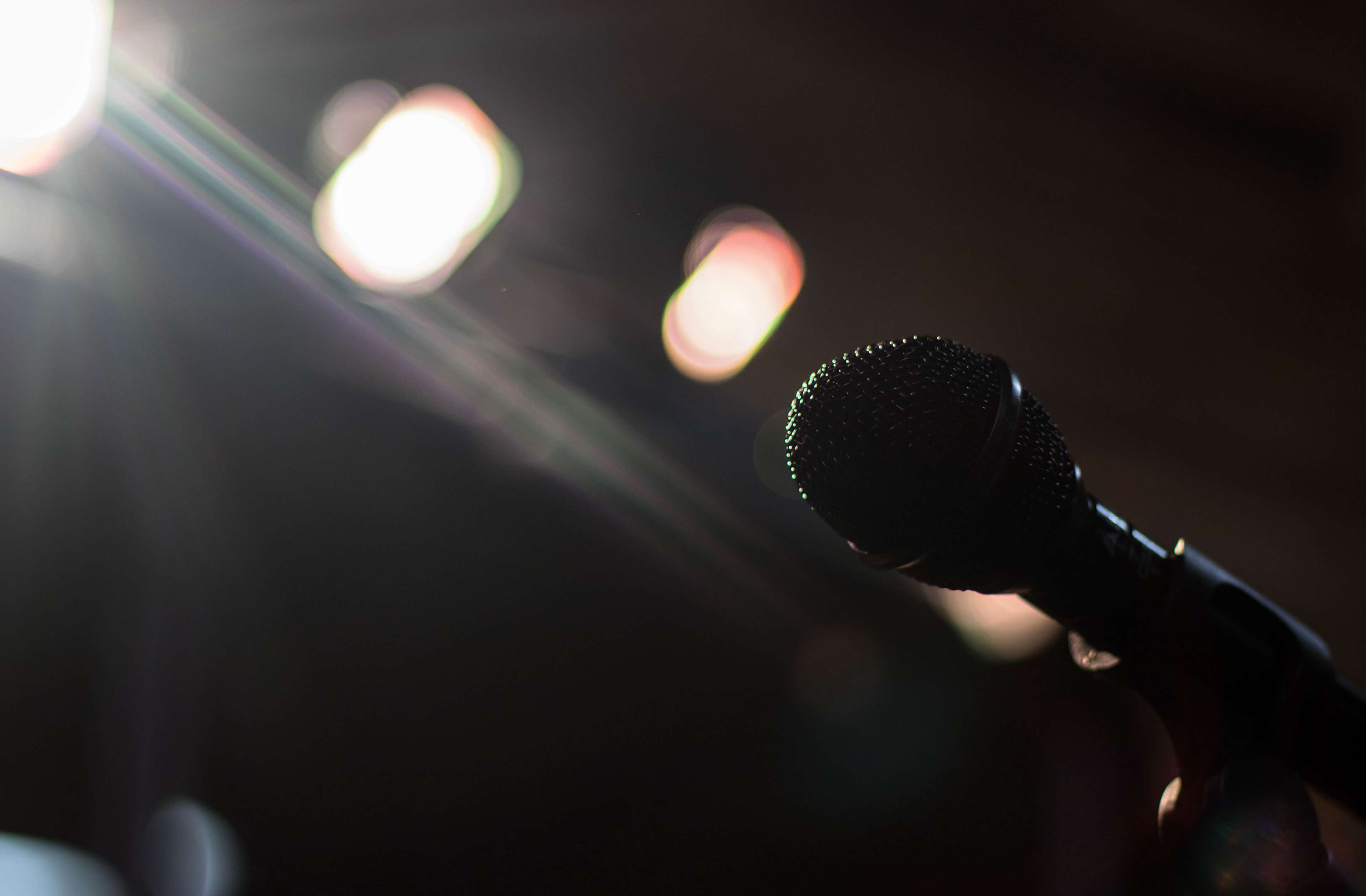 Microphone on a dark stage with bright lights HD Wallpaper