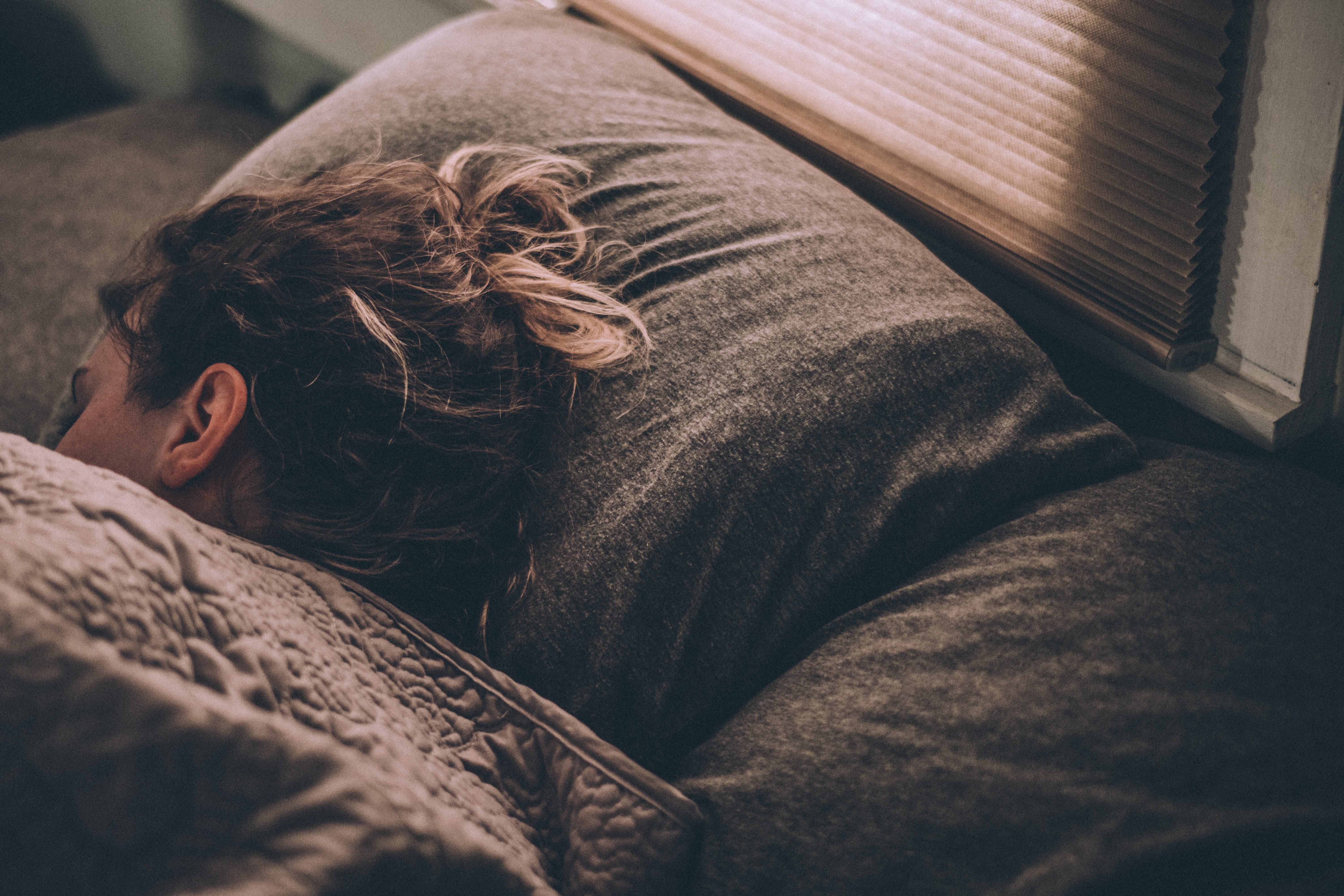 Woman sleeping on a bed near a window HD Wallpaper