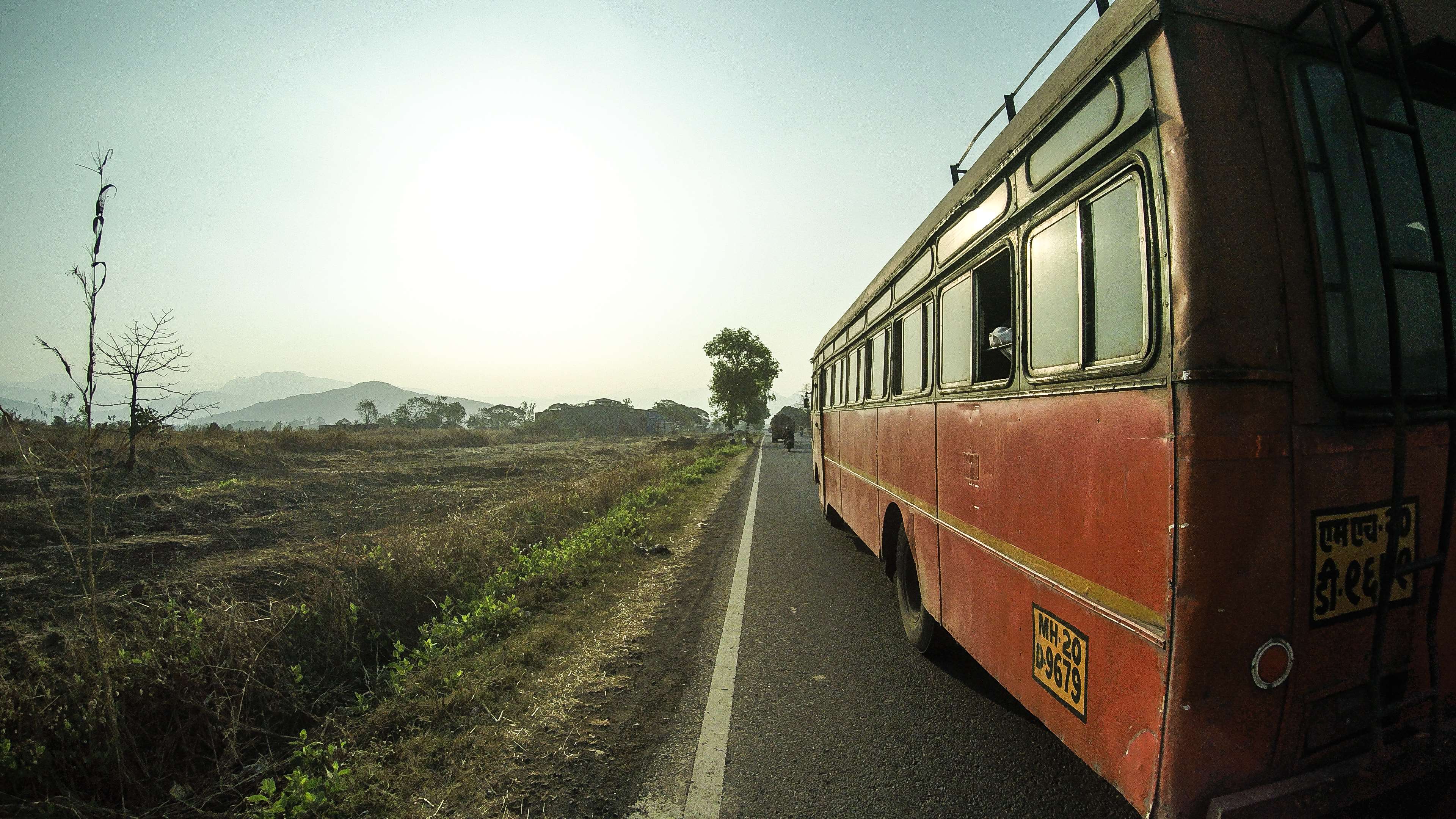 Red bus on a road in India HD Wallpaper