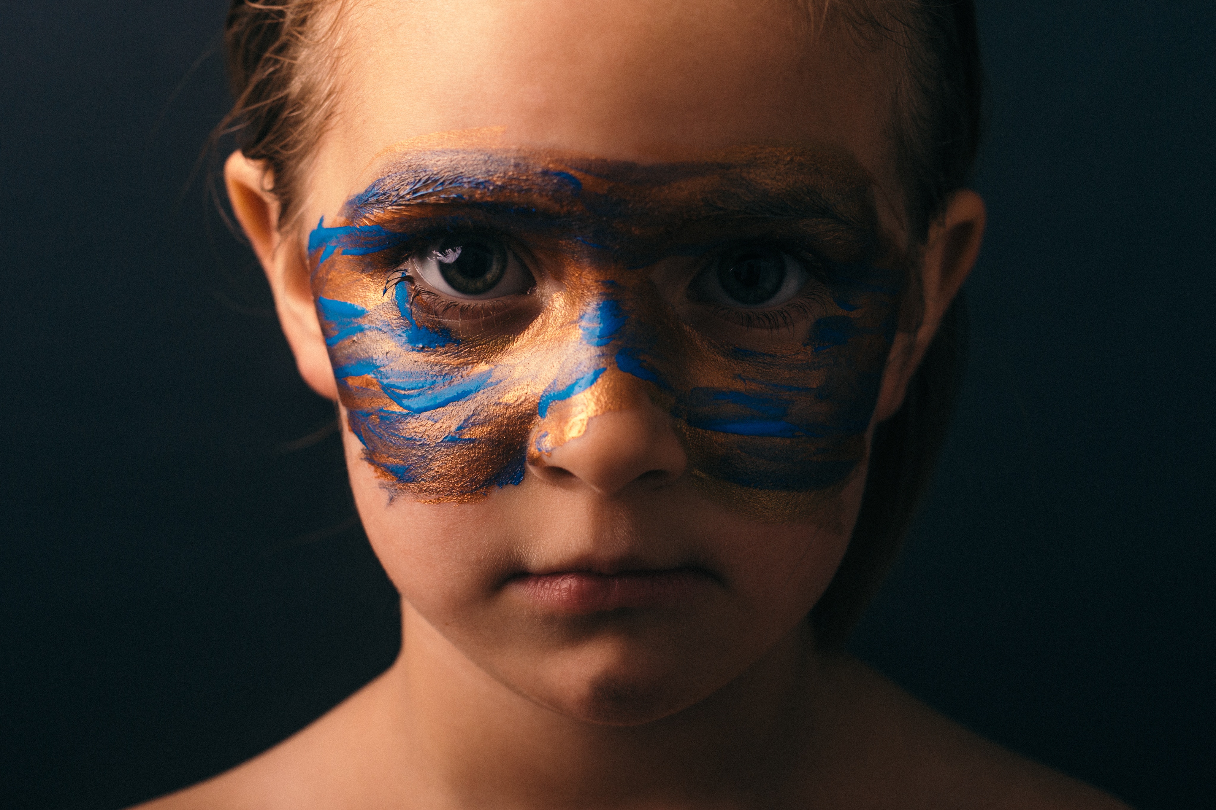Child with painted face looking at camera HD Wallpaper