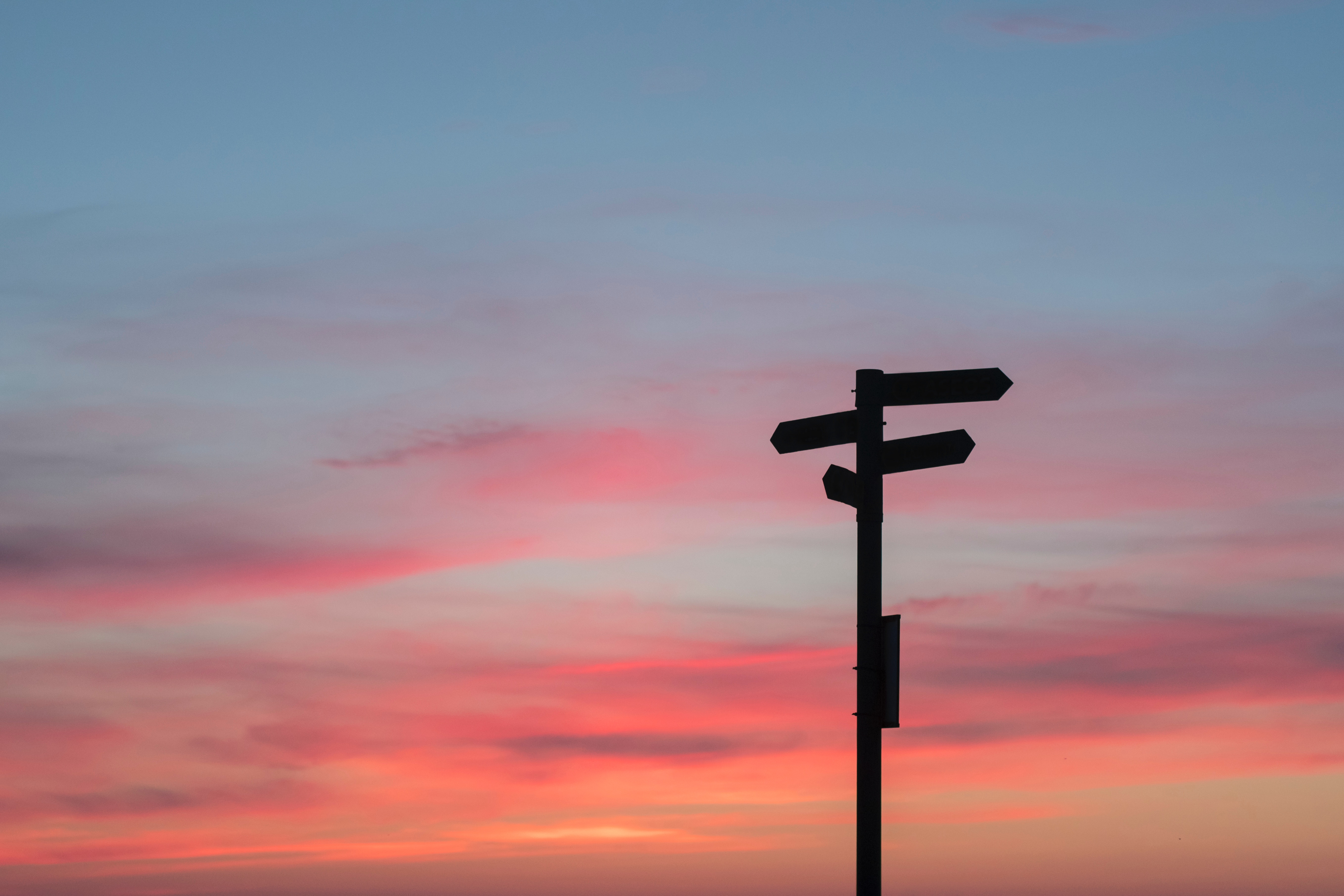 Silhouette of a signpost against a sunset sky HD Wallpaper