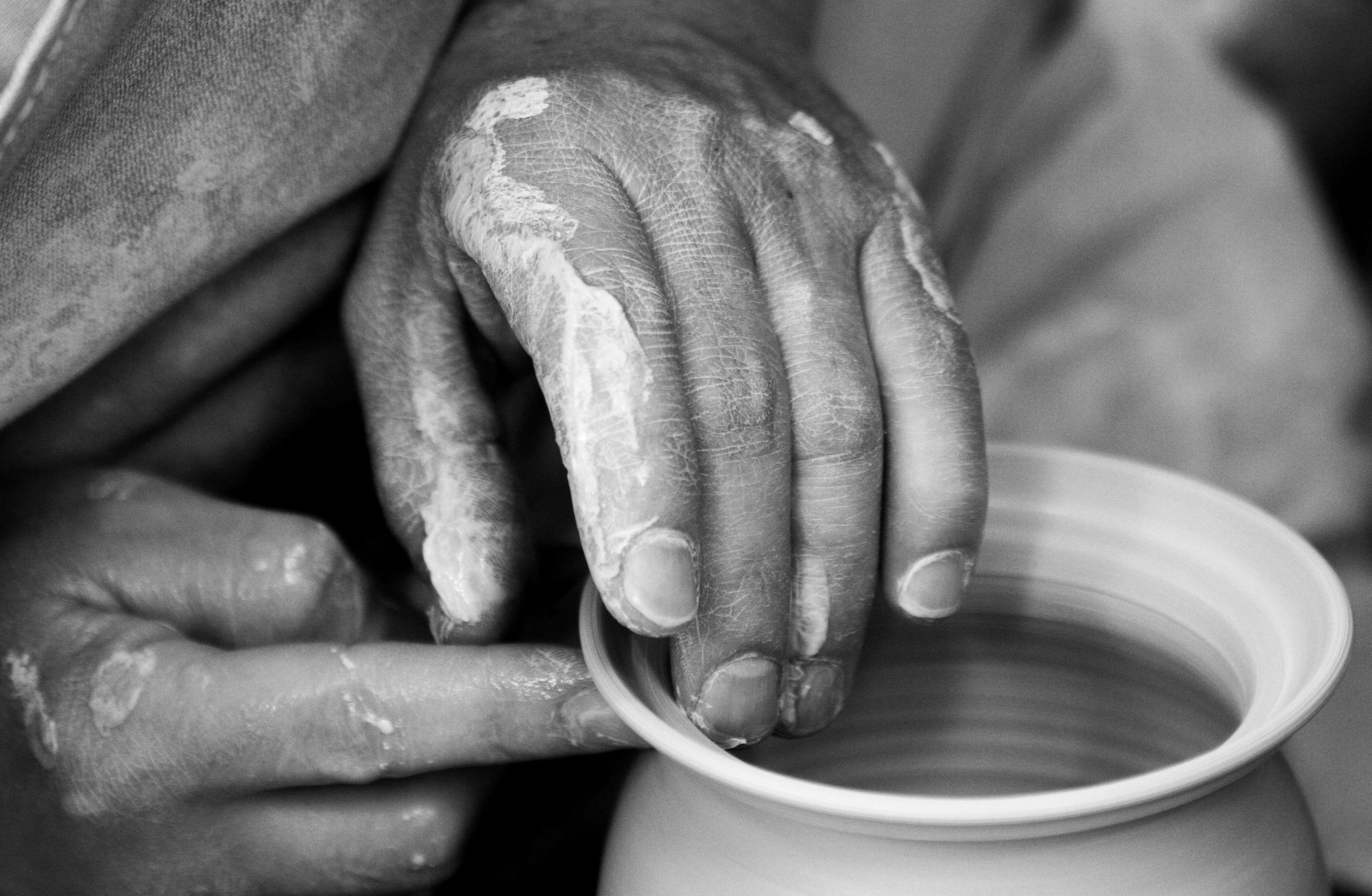 Hands shaping clay on a pottery wheel HD Wallpaper