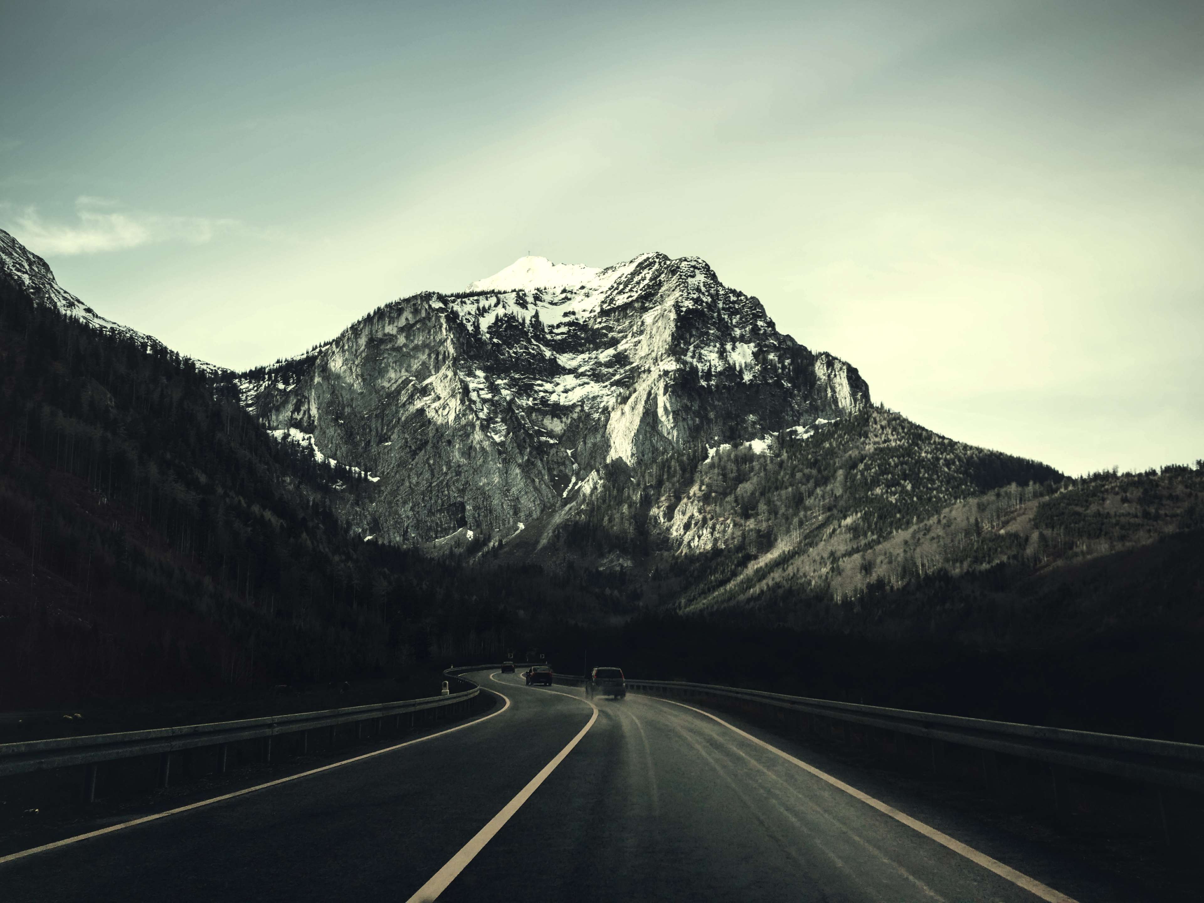 Road leading to snow-capped mountains HD Wallpaper