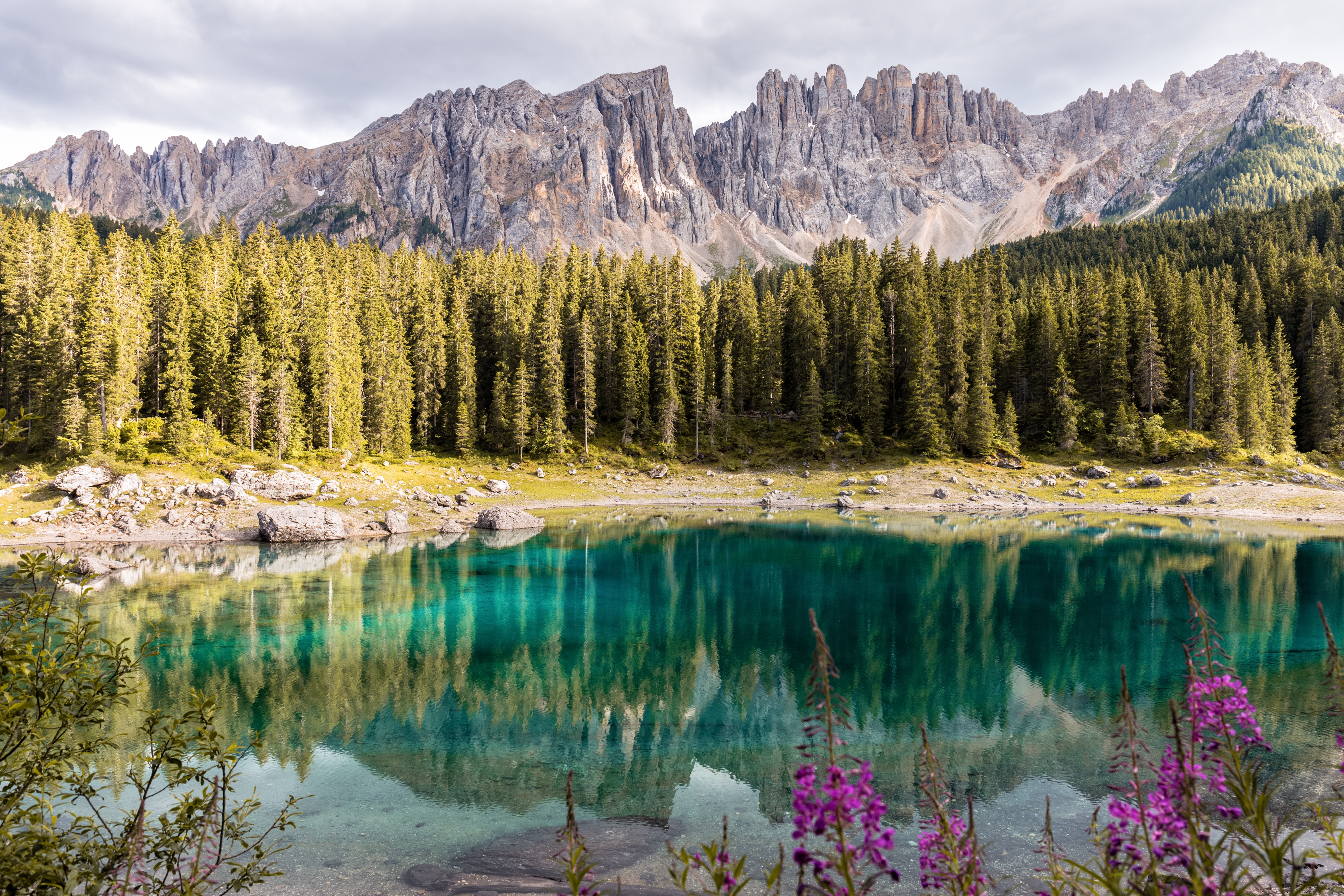 Turquoise lake reflecting mountains and forest HD Wallpaper