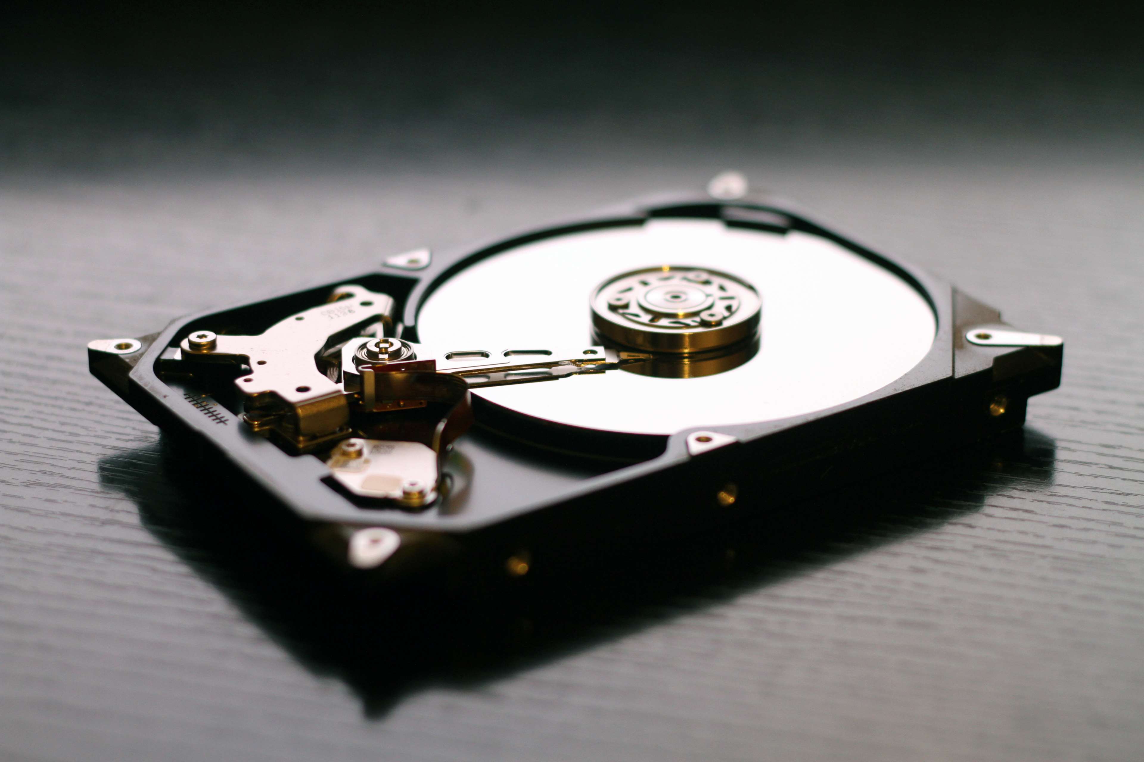 Close up of a hard disk drive mechanism HD Wallpaper