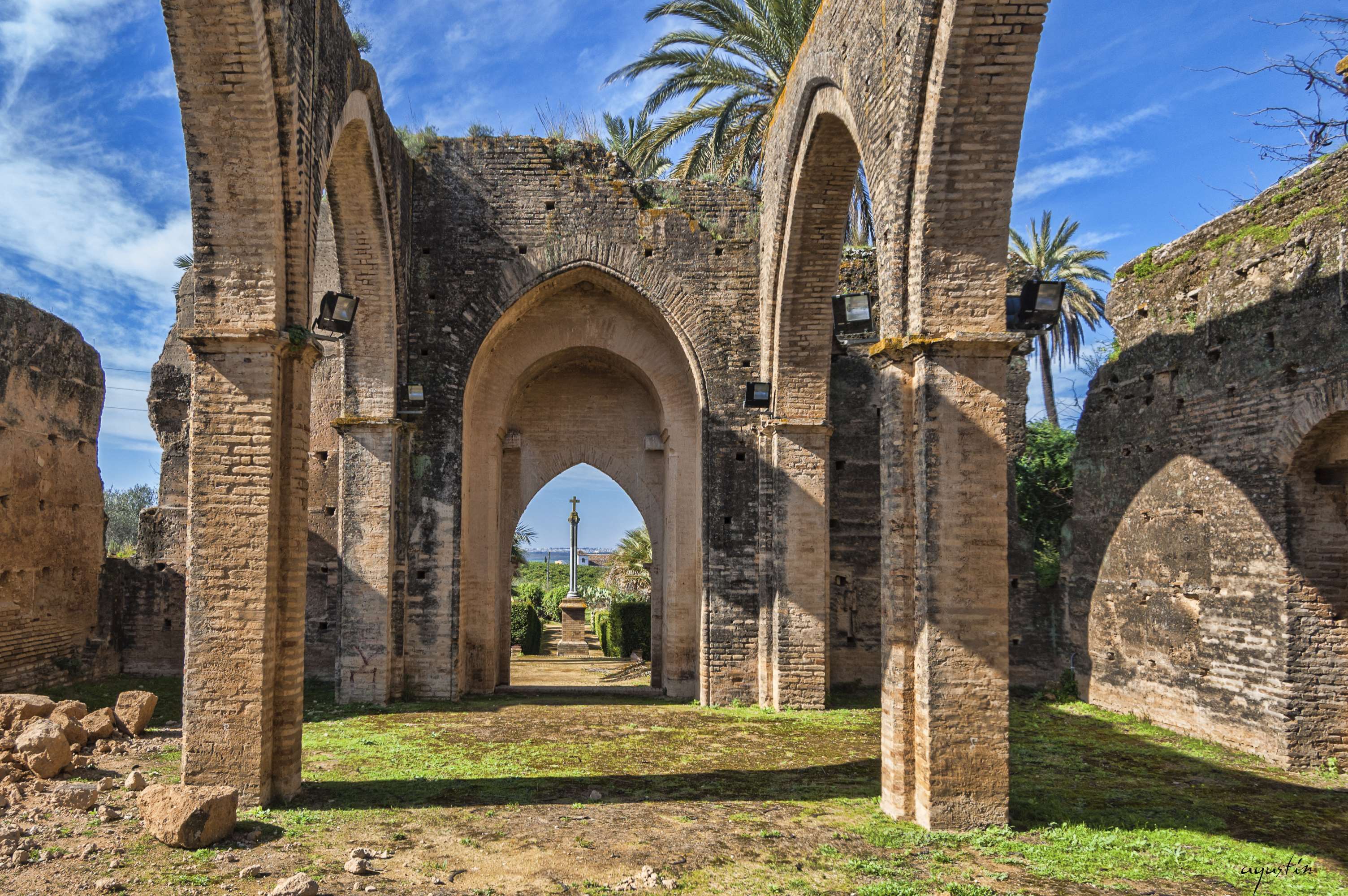 Ruins of Castilleja de Talhara with arches and palm trees HD Wallpaper