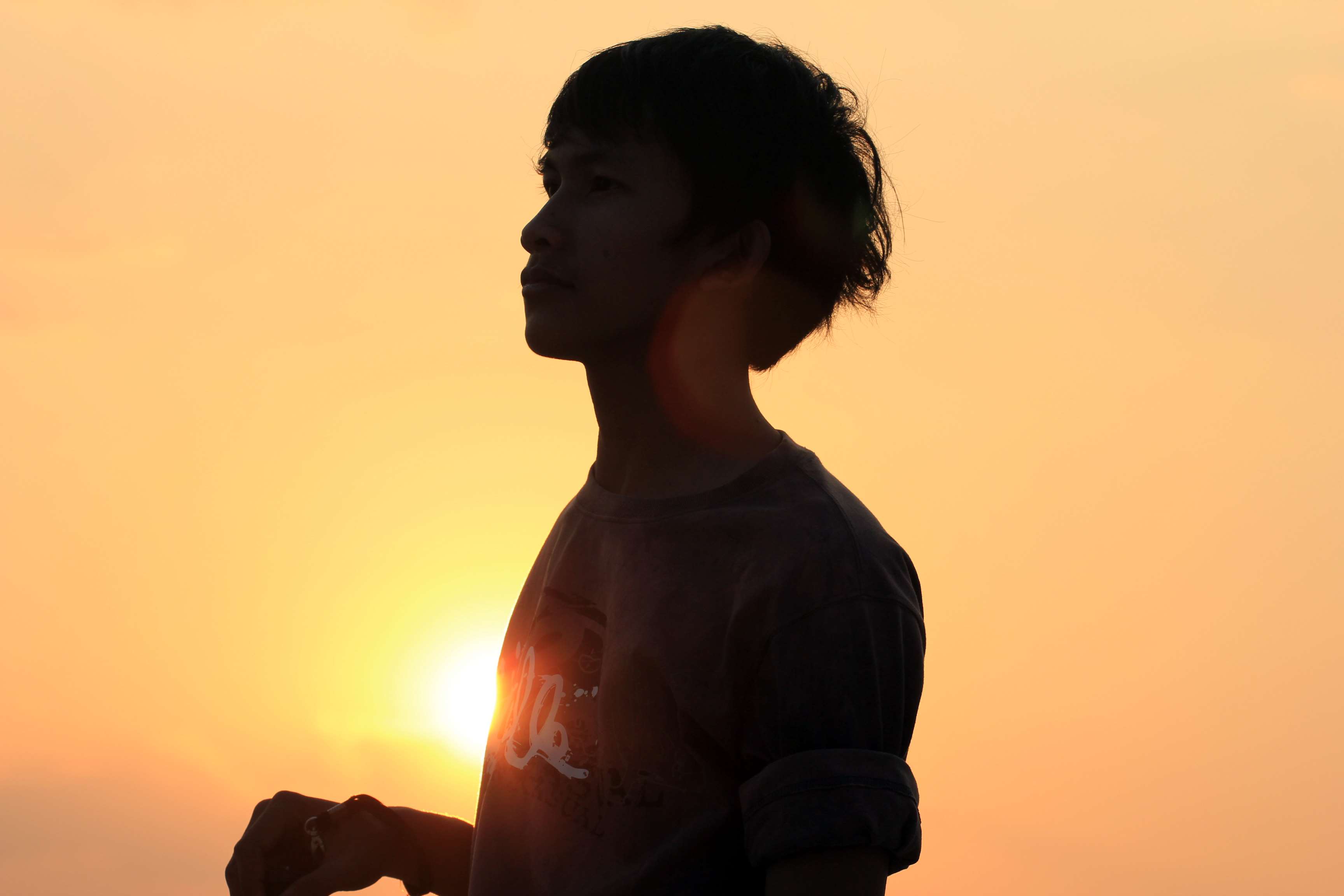 Silhouette of a boy against the sunset HD Wallpaper