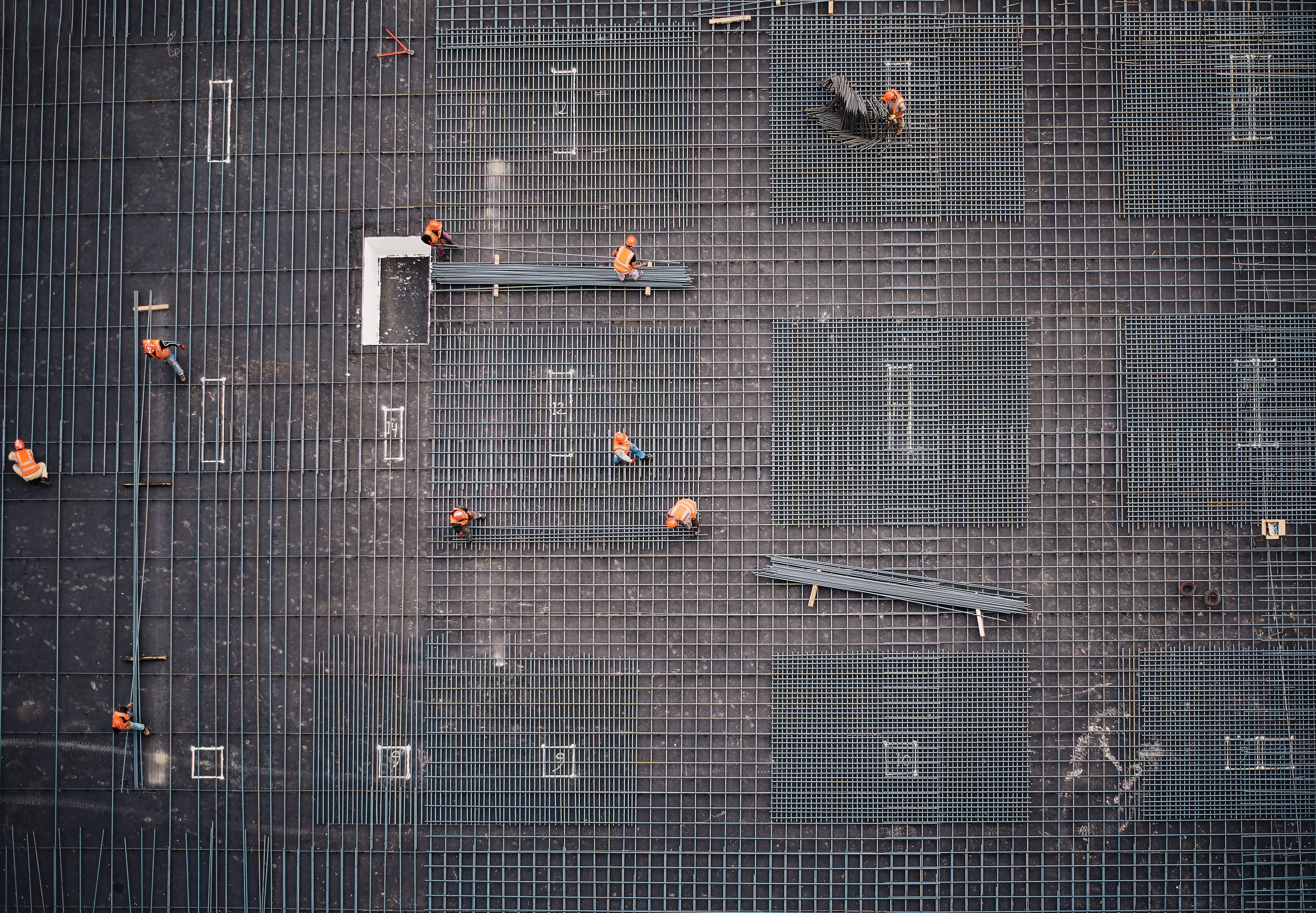 Construction workers on steel rebar grid from above HD Wallpaper