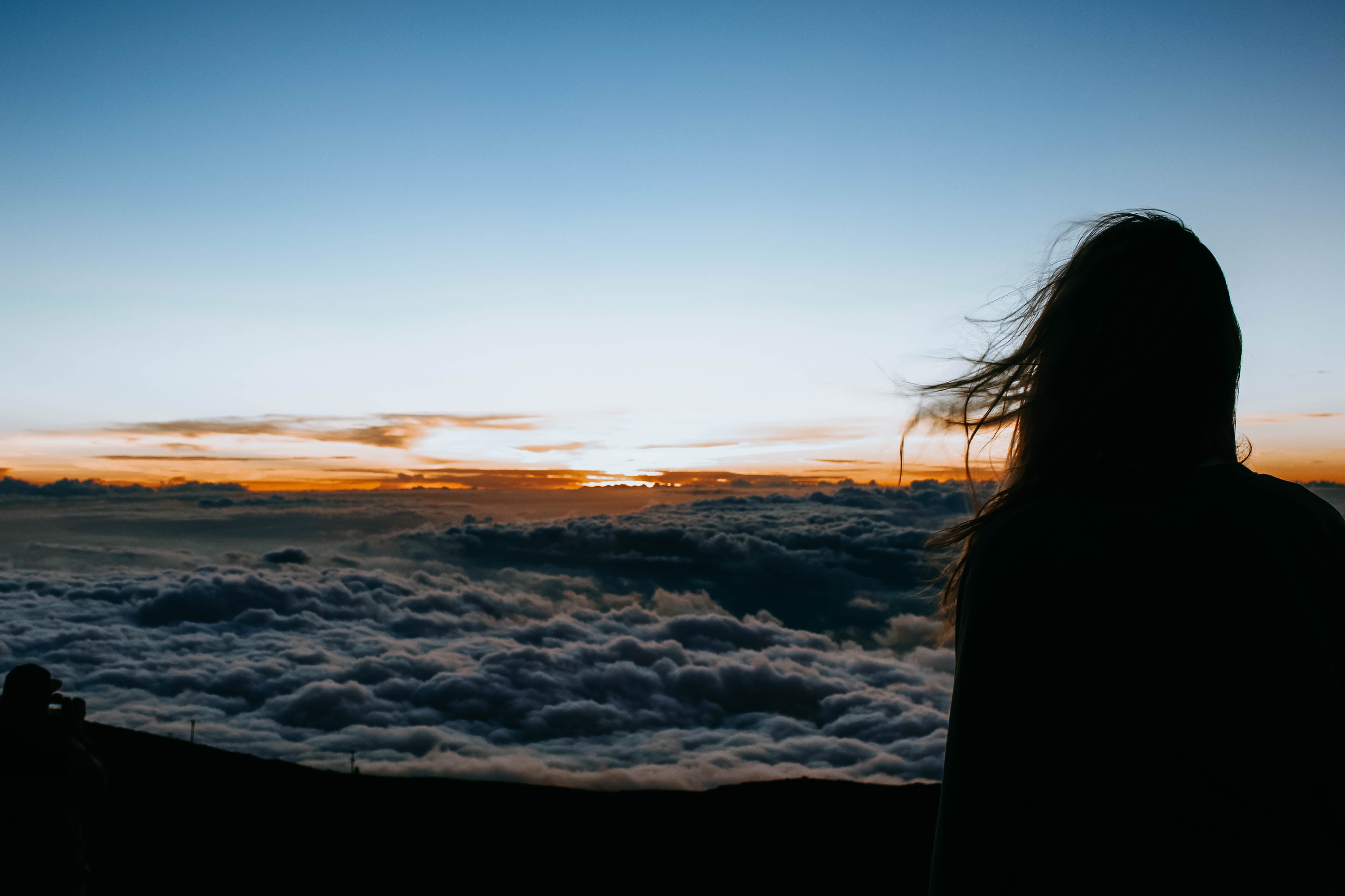 Silhouette of a woman above clouds at sunset in Hawaii HD Wallpaper