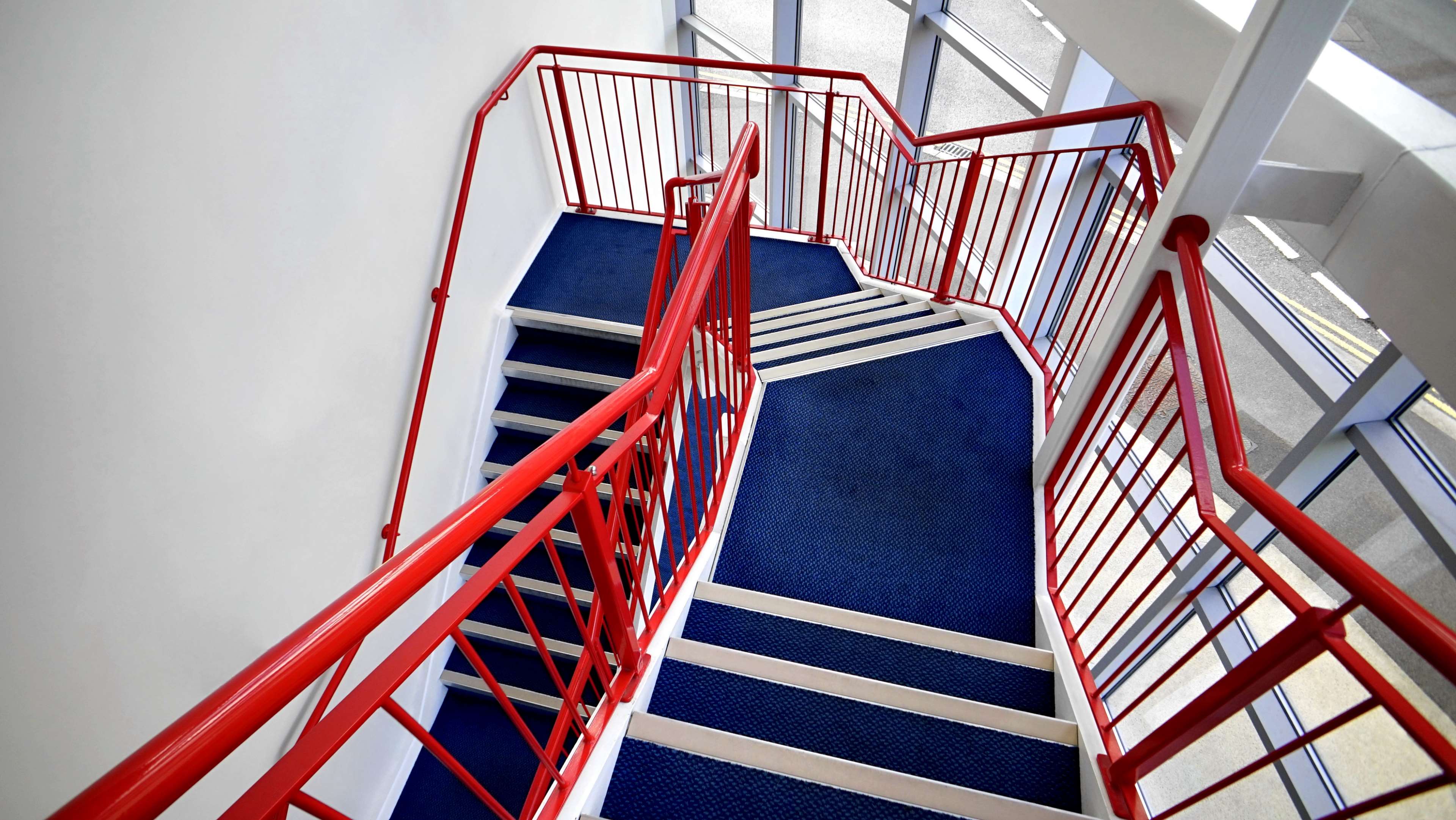 Modern Staircase with Red Handrails and Blue Carpet HD Wallpaper