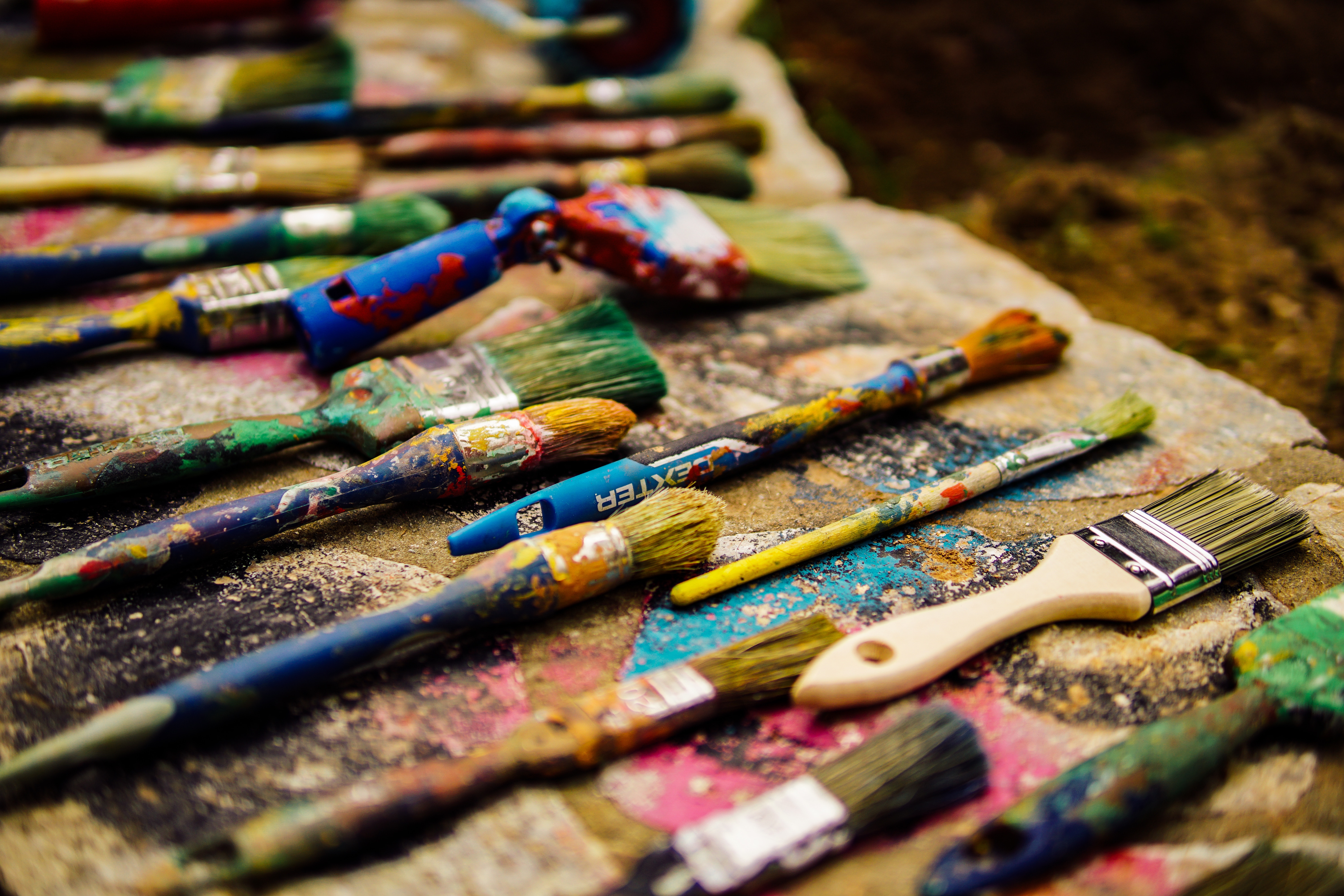 Assortment of paint brushes with colorful paint splatters HD Wallpaper