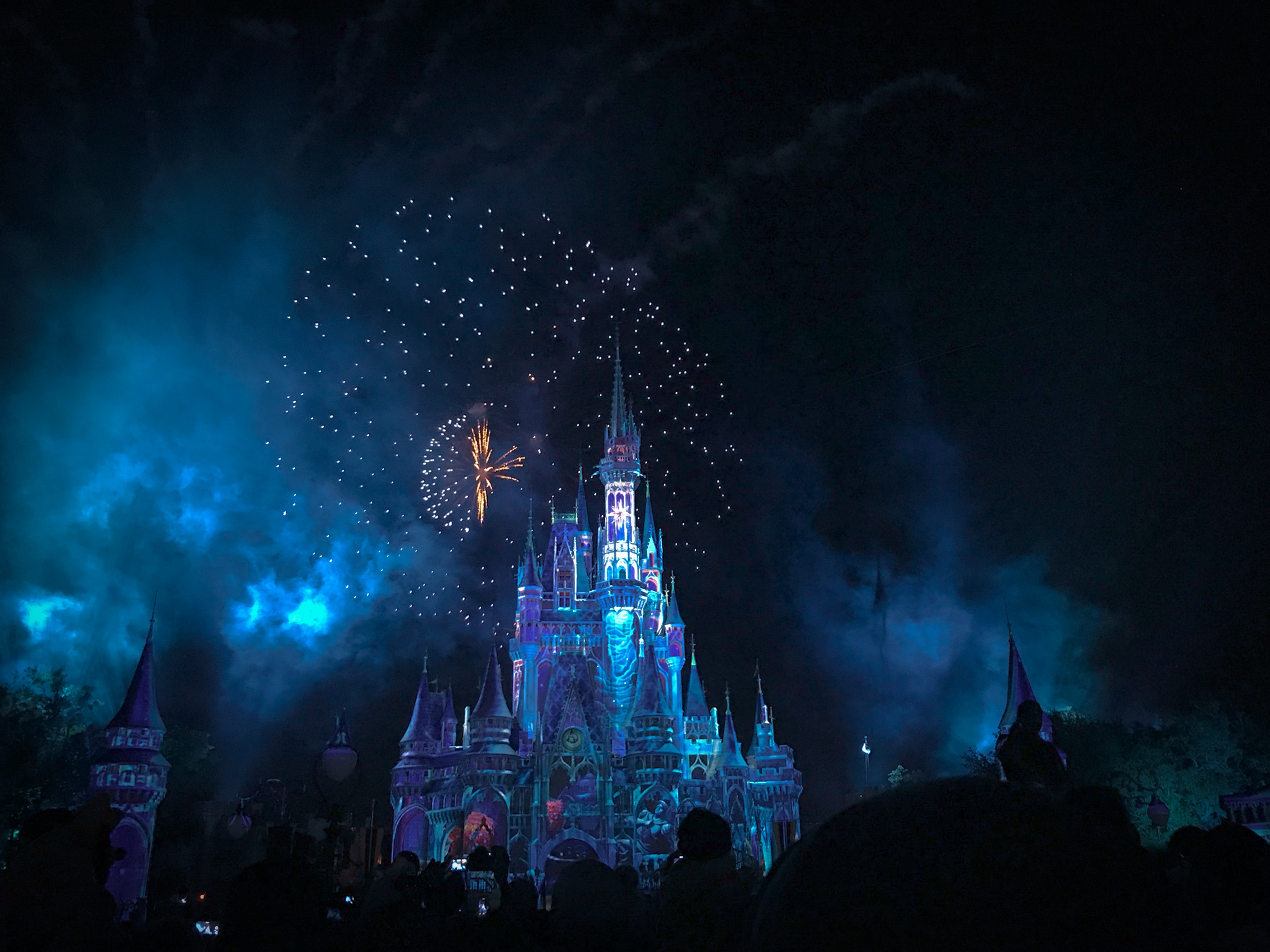 Disney castle with fireworks and blue smoke at night HD Wallpaper