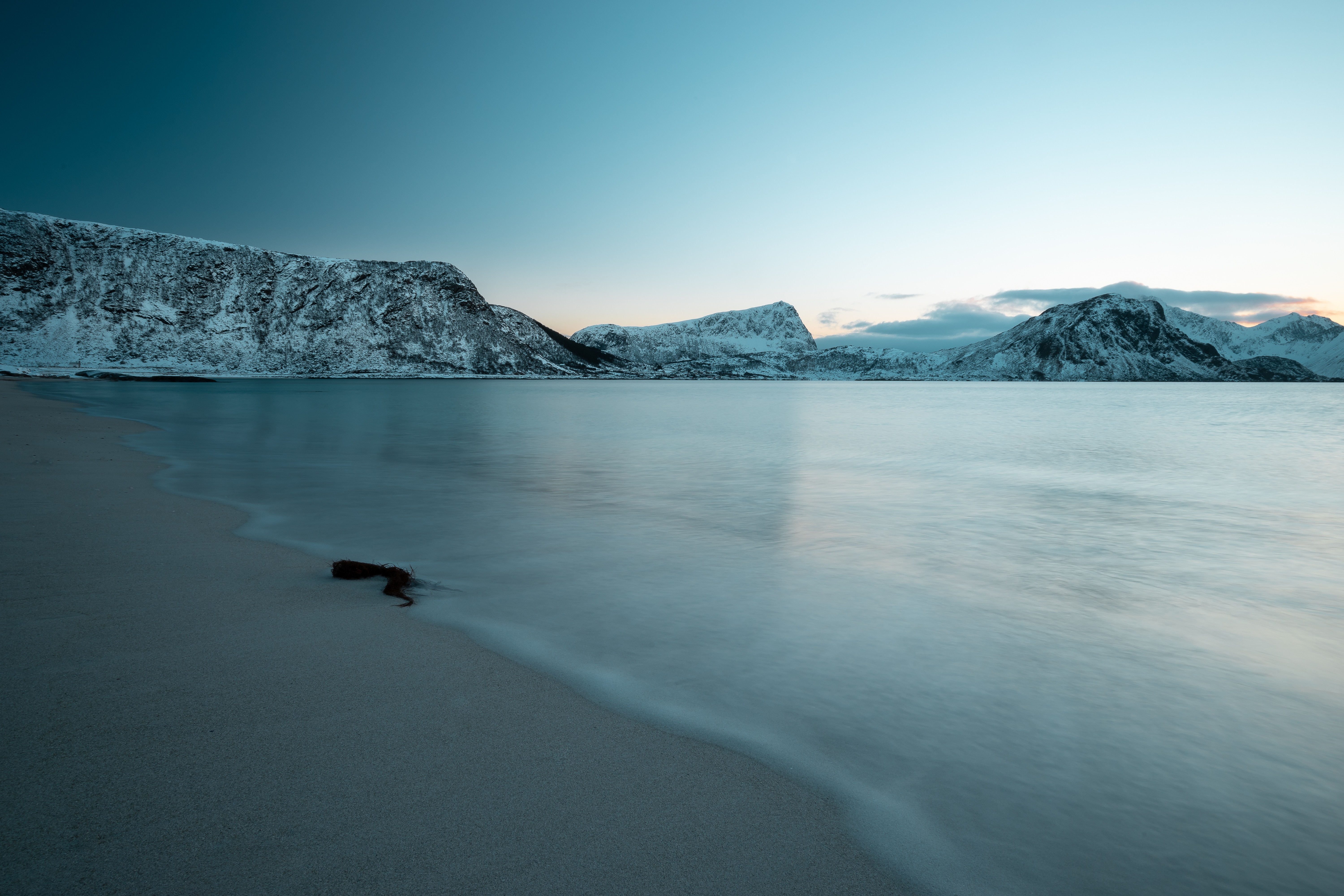 Long exposure of snowy mountains and beach in Lofoten, Norway HD Wallpaper