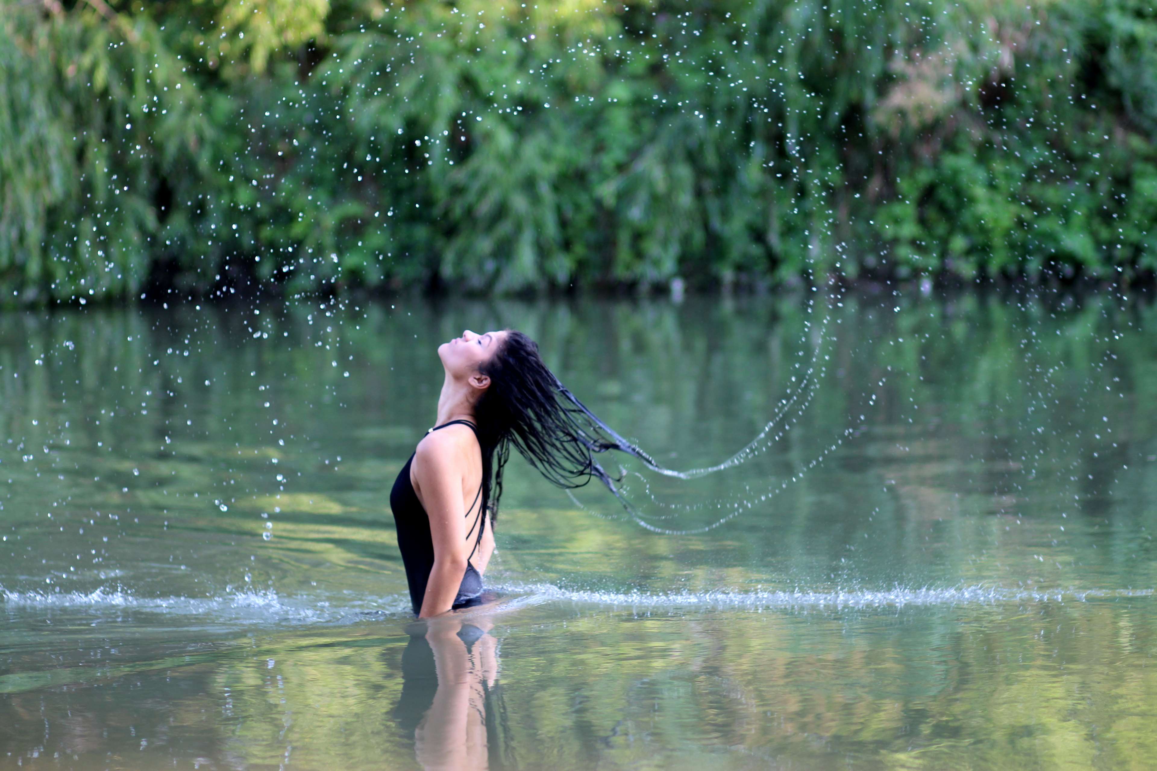 Woman splashing water in a lake HD Wallpaper
