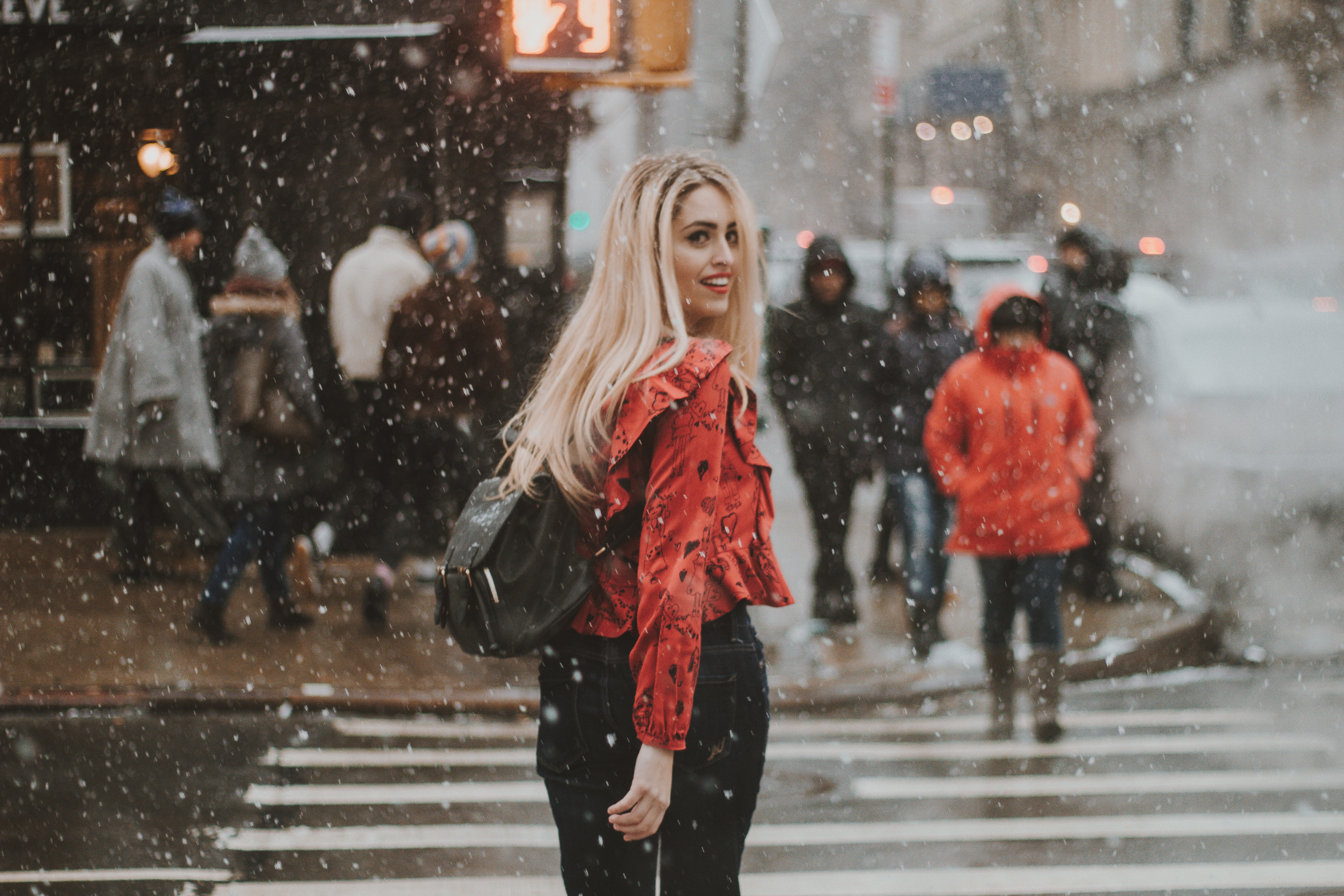 Woman in red top crossing street in NYC during snow HD Wallpaper