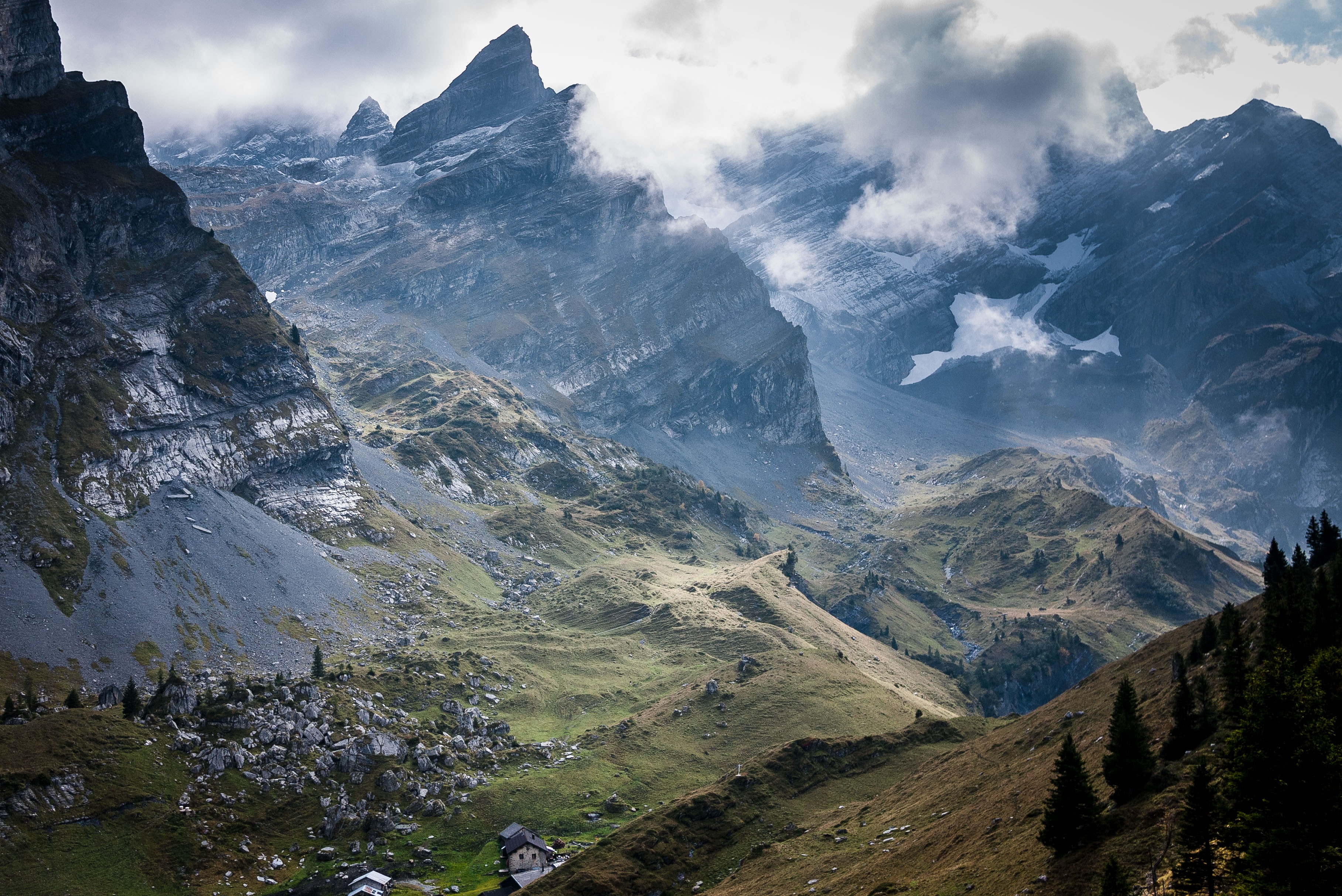 Misty mountain peaks and a valley with houses HD Wallpaper