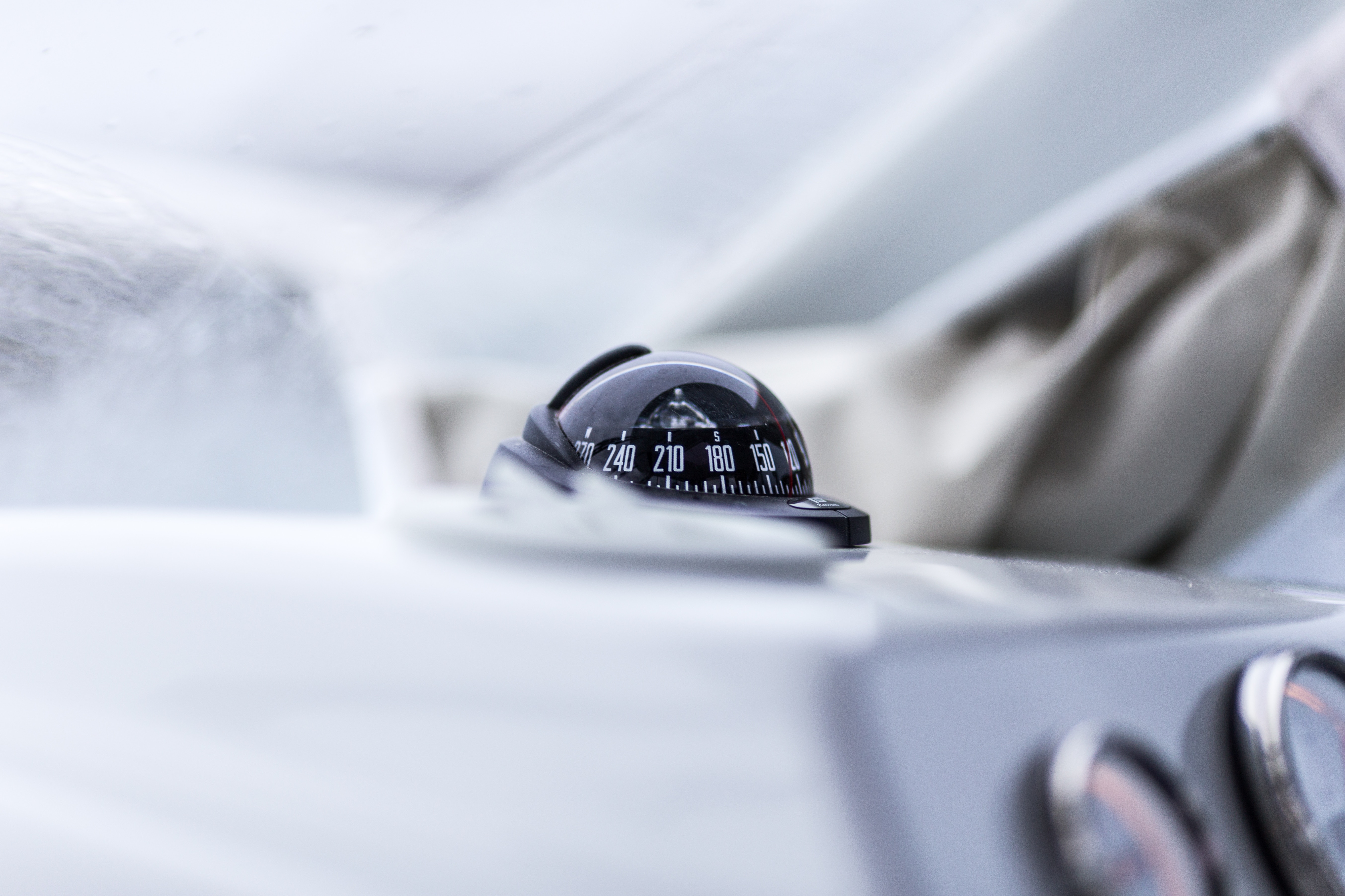 Close-up of a boat compass on a white dashboard HD Wallpaper