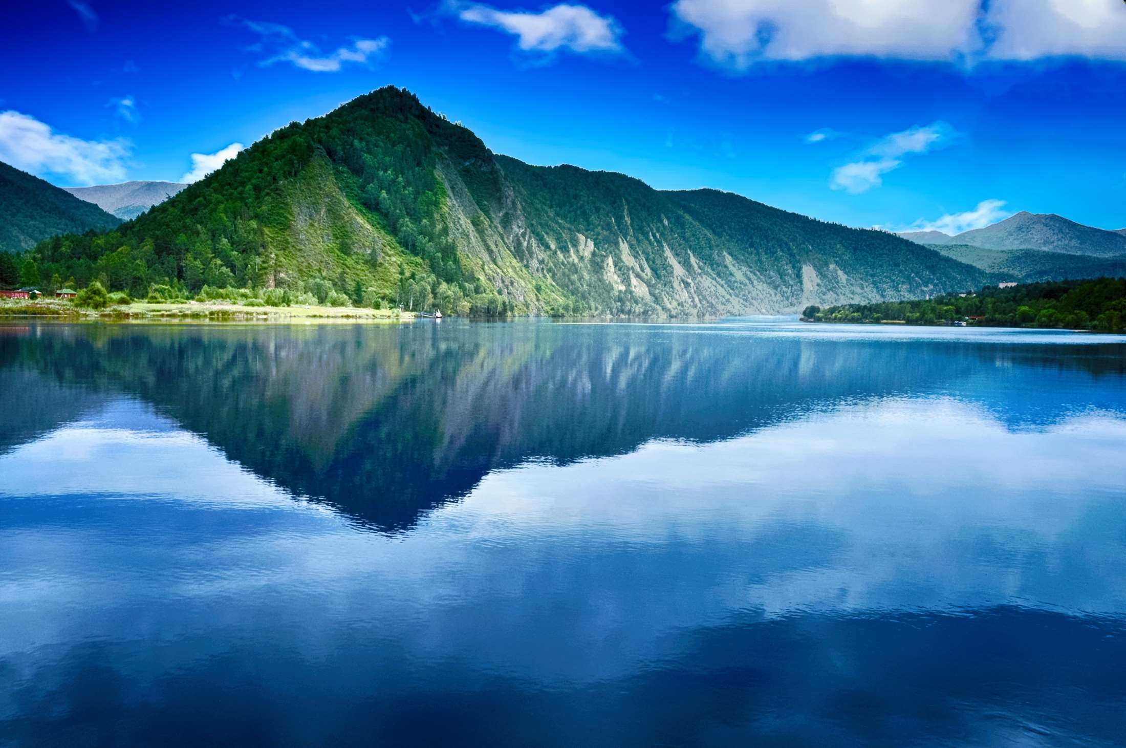 Majestic mountain reflected in a clear blue lake under a cloudy sky HD Wallpaper