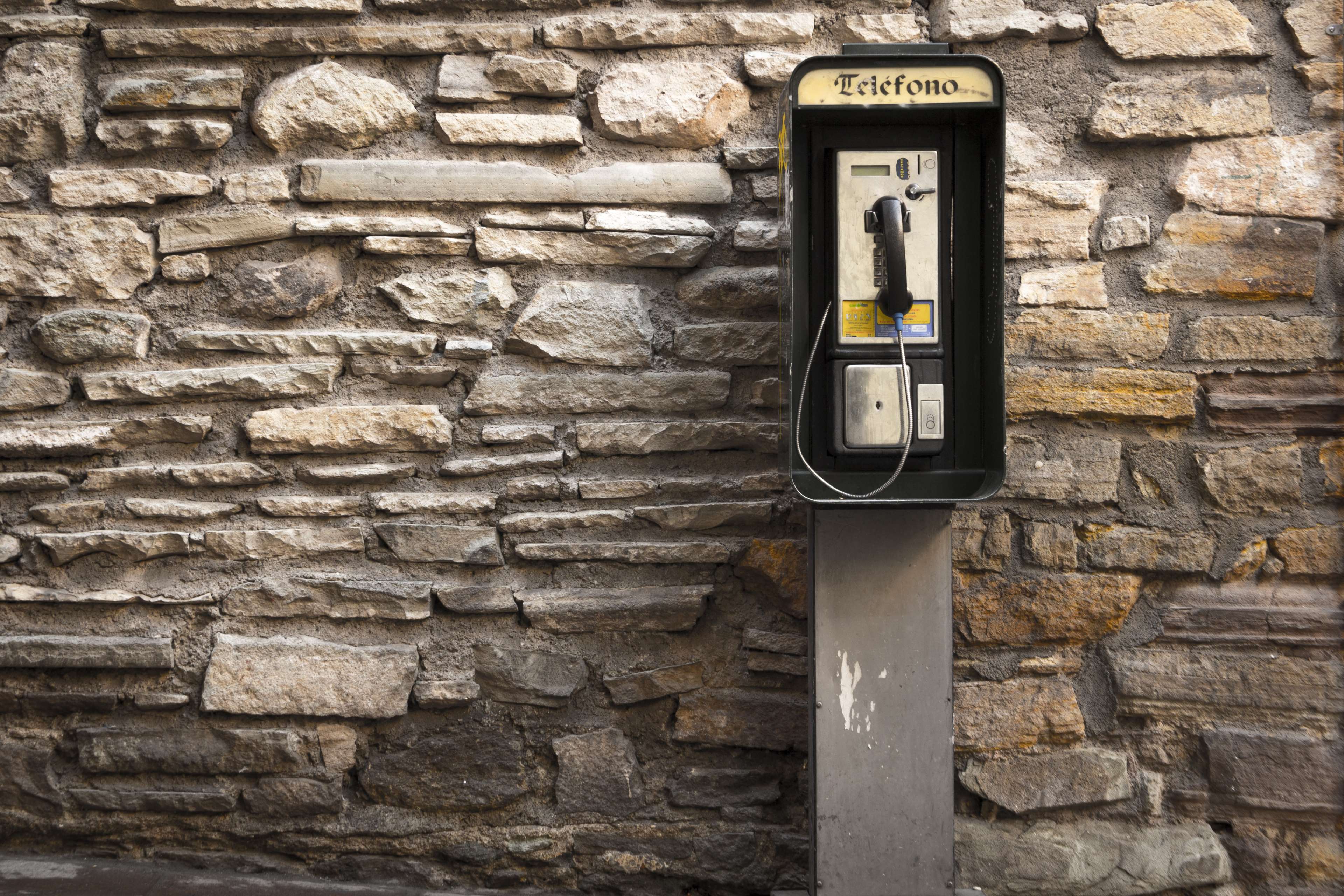 Payphone on a stone wall HD Wallpaper
