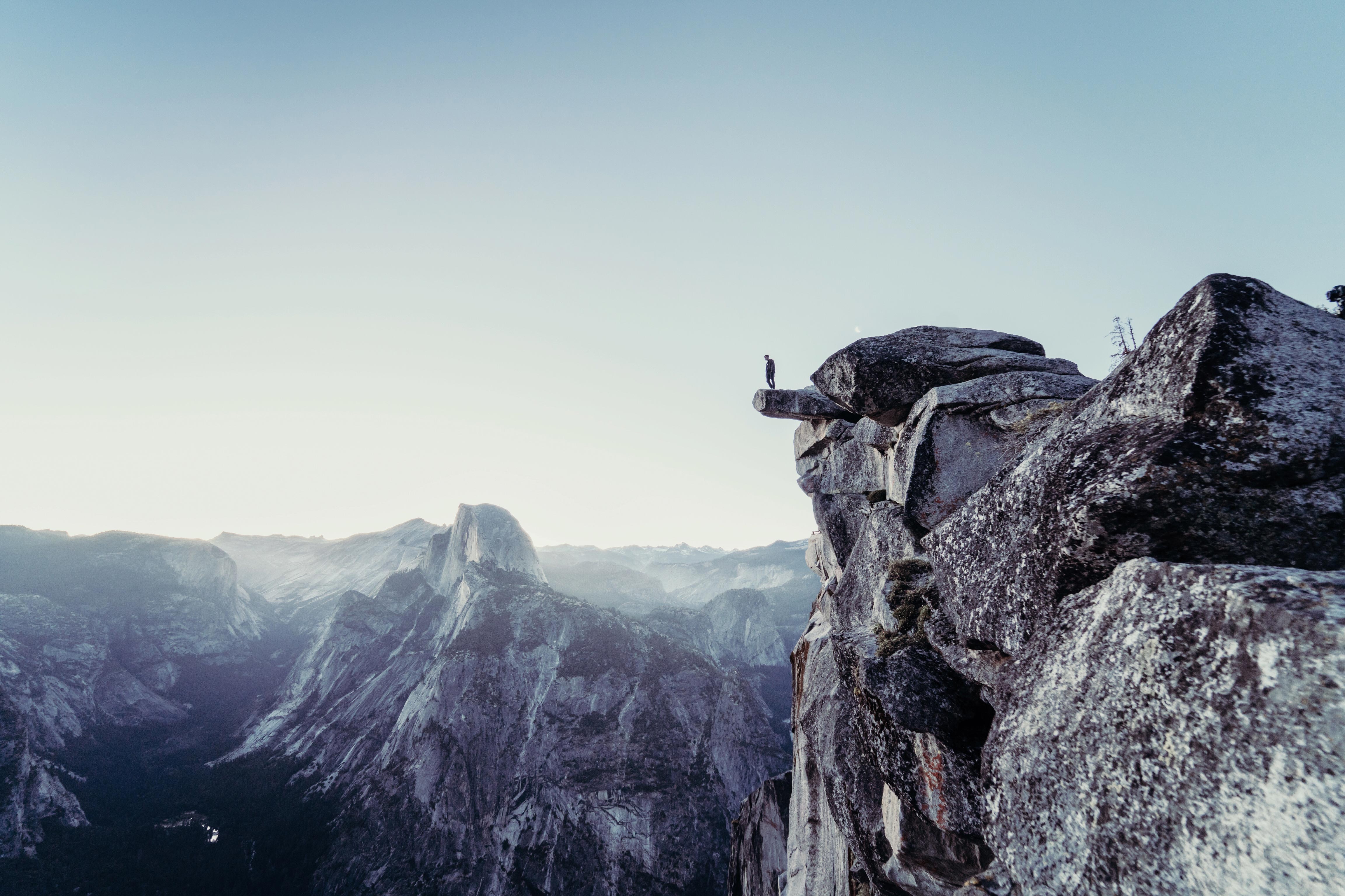Man standing on a cliff edge in Yosemite National Park HD Wallpaper