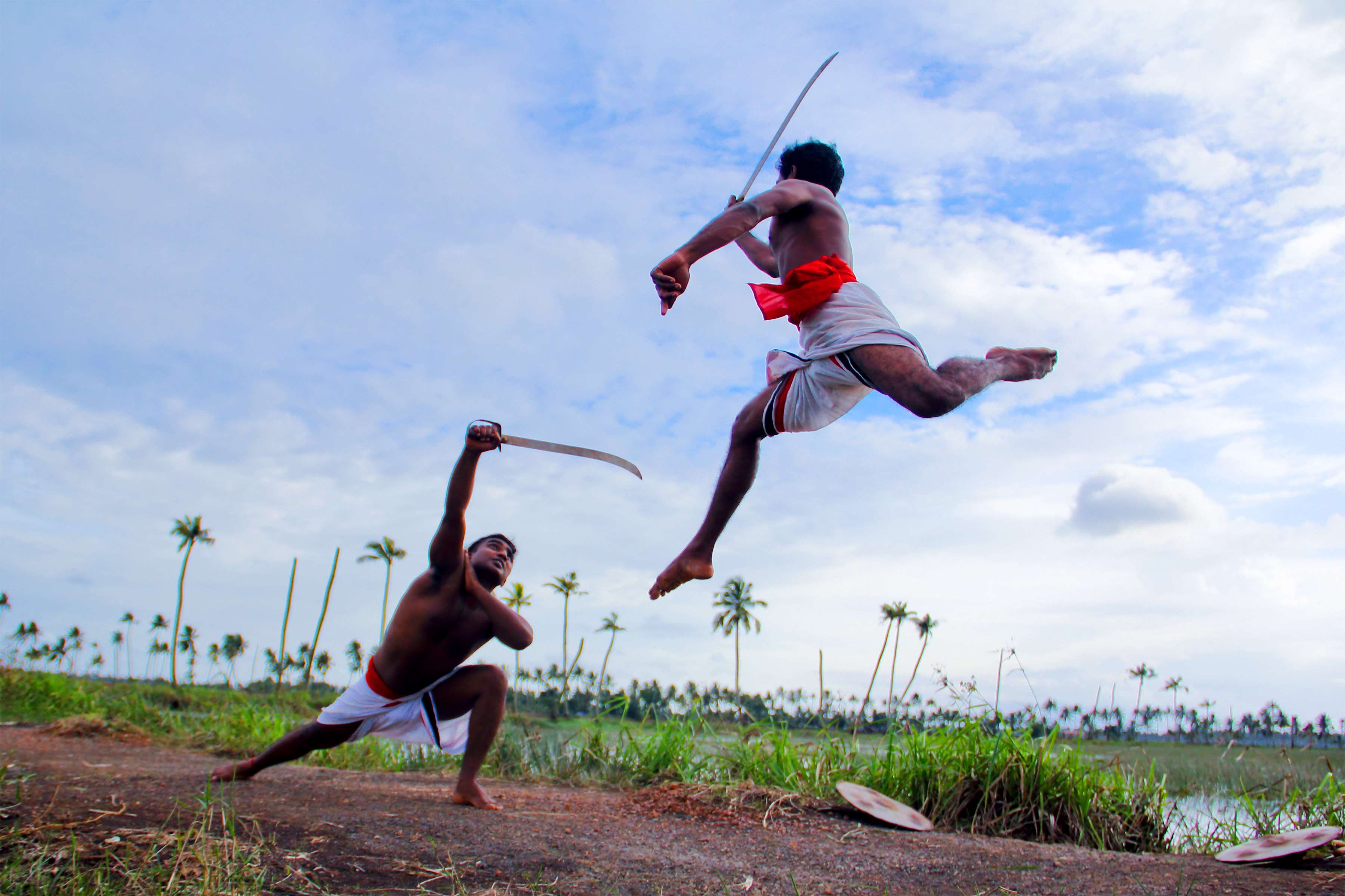 Two men practicing Kalaripayattu with swords in India HD Wallpaper