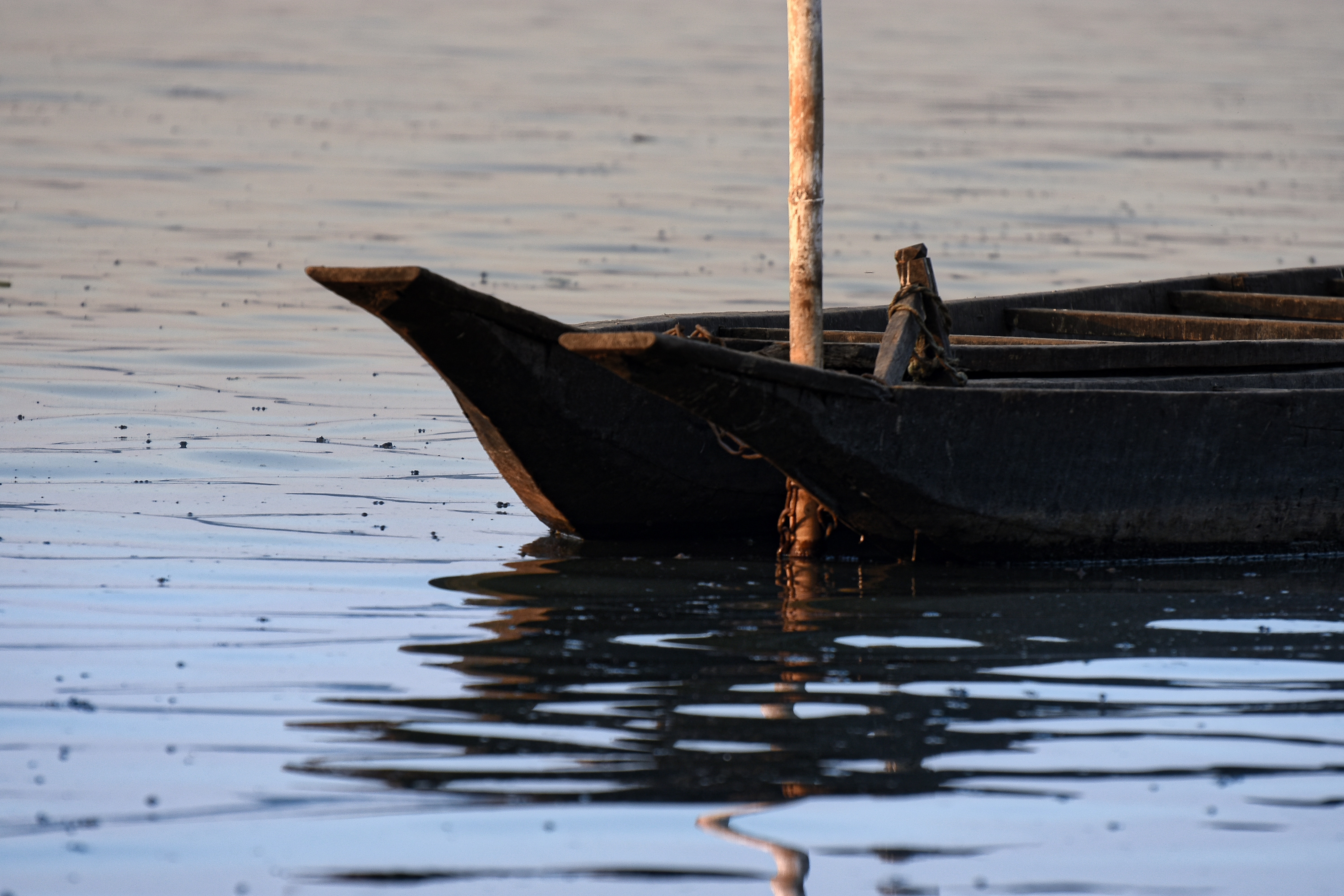 Wooden boat floating on calm water with reflection HD Wallpaper