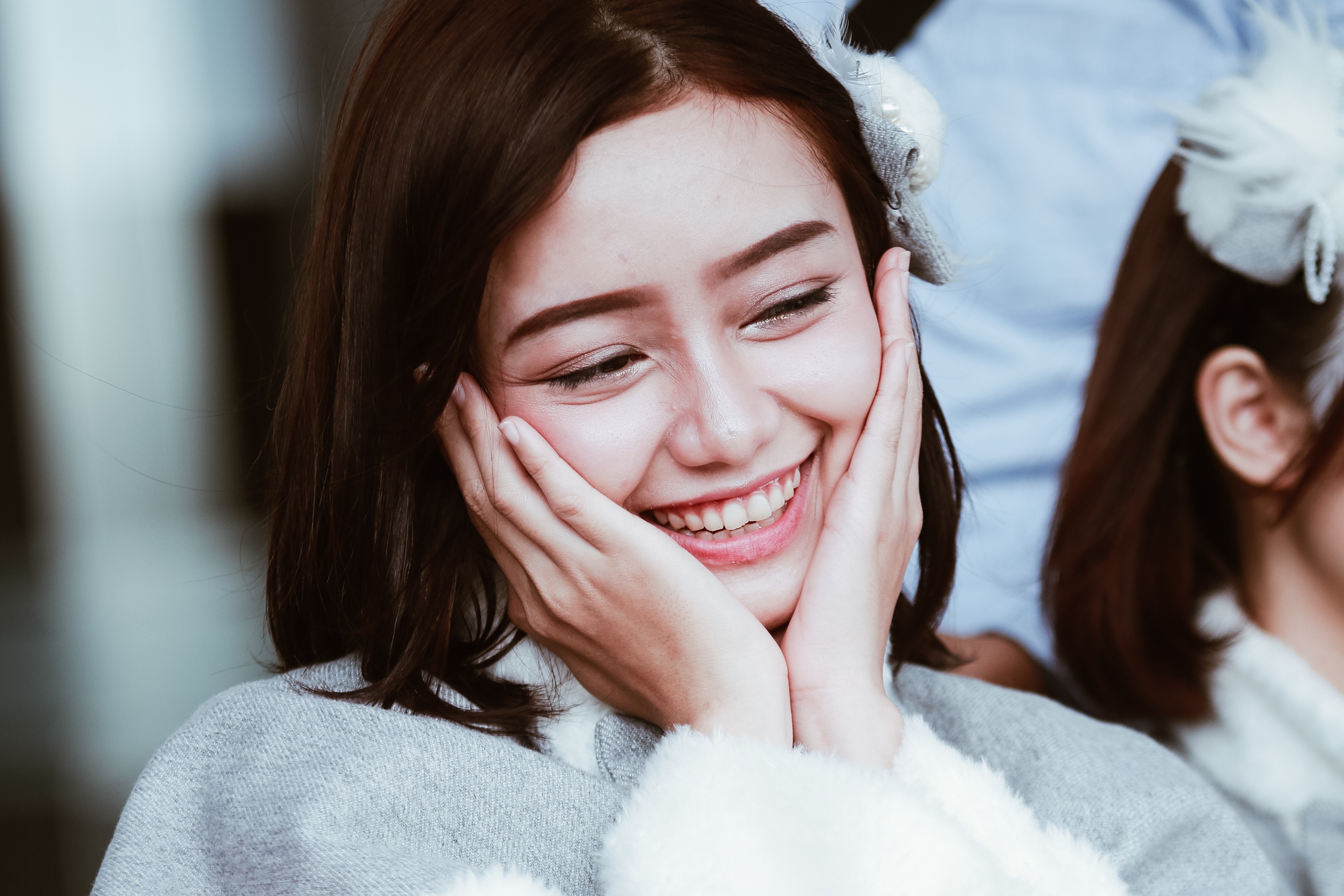 Young woman with hands on cheeks smiling HD Wallpaper