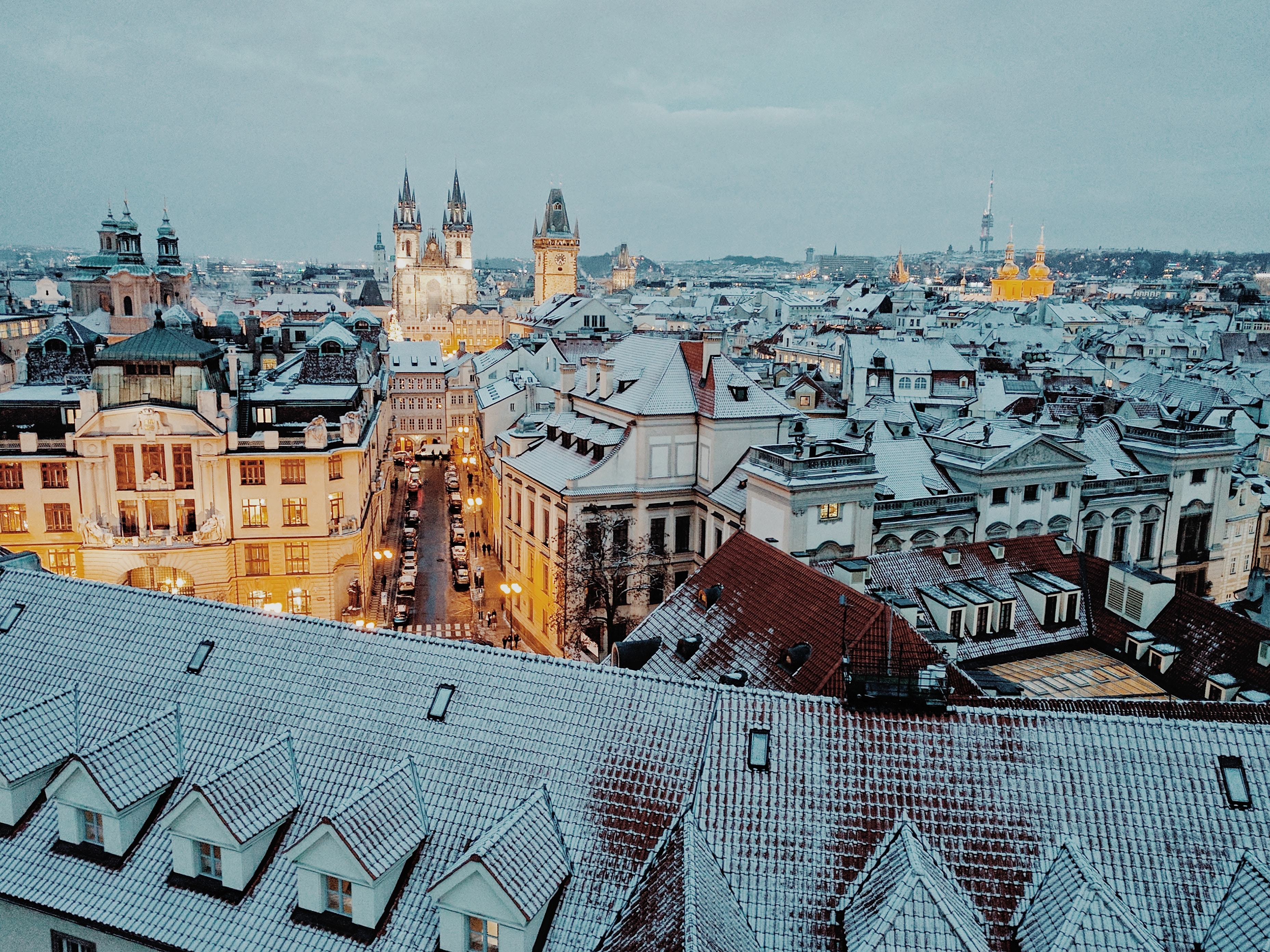 Snowy Prague cityscape with historic architecture at dusk HD Wallpaper