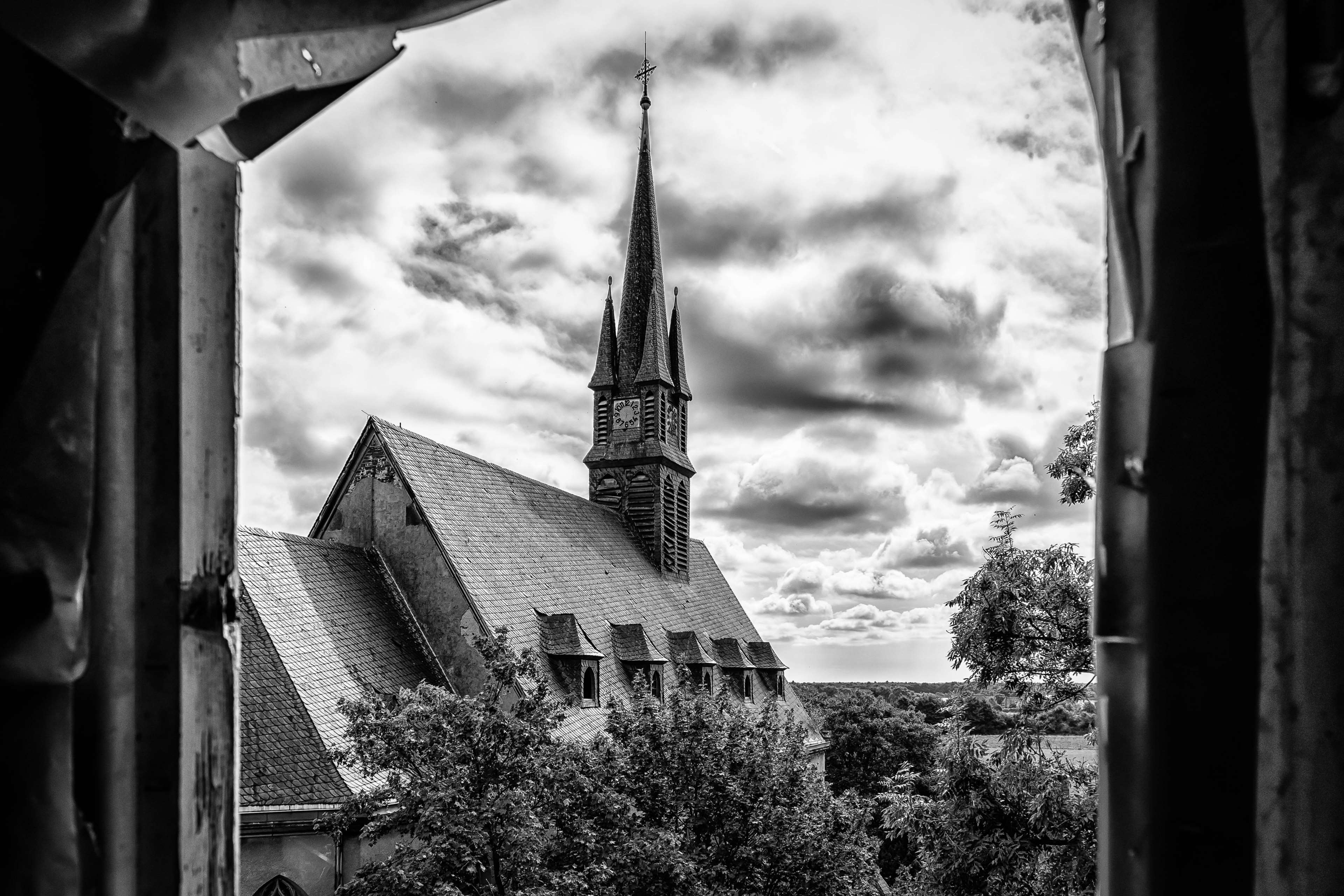 Church tower with spire and clock, seen through a broken frame HD Wallpaper