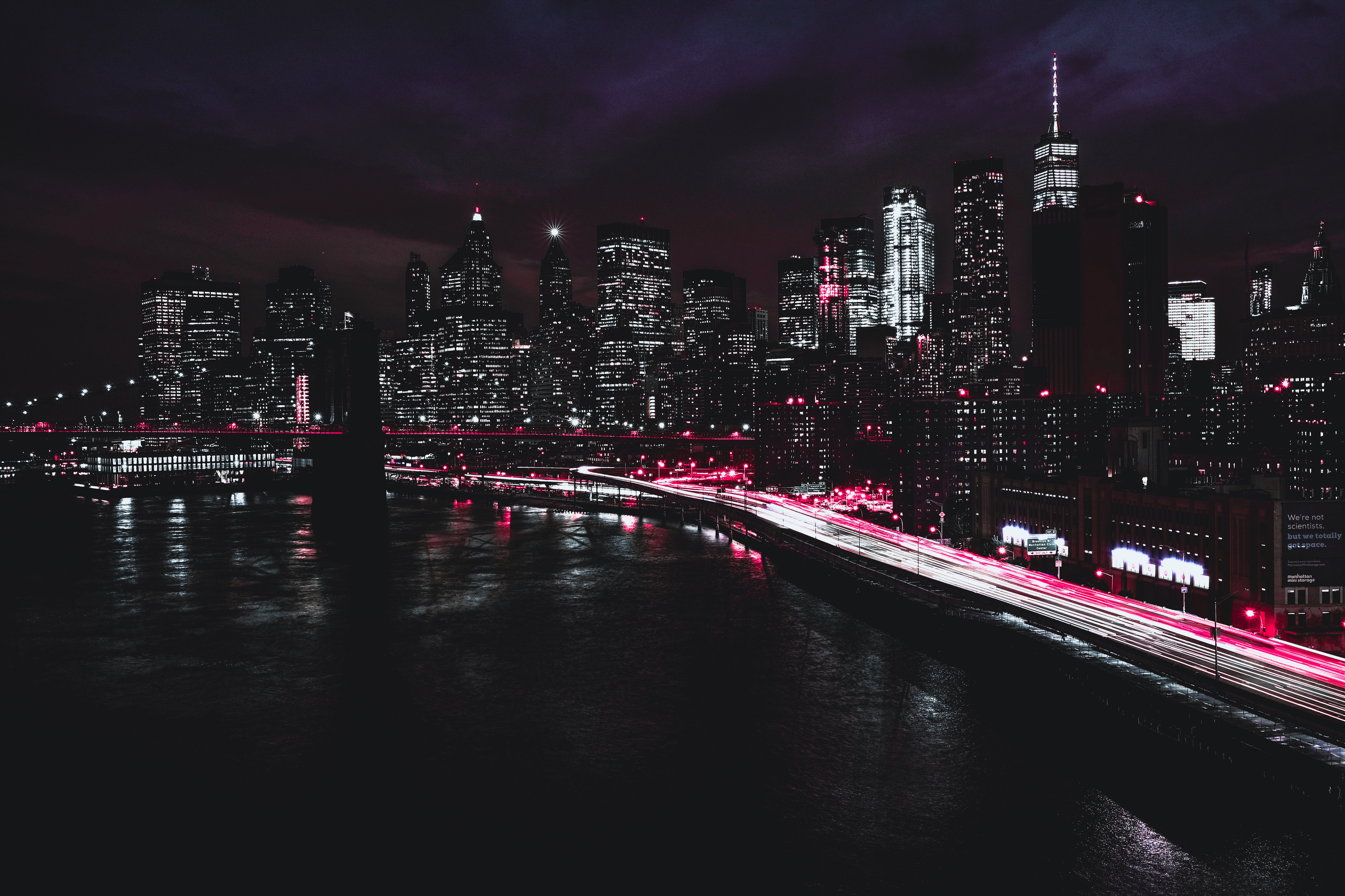 New York City skyline at night with bridge and river HD Wallpaper
