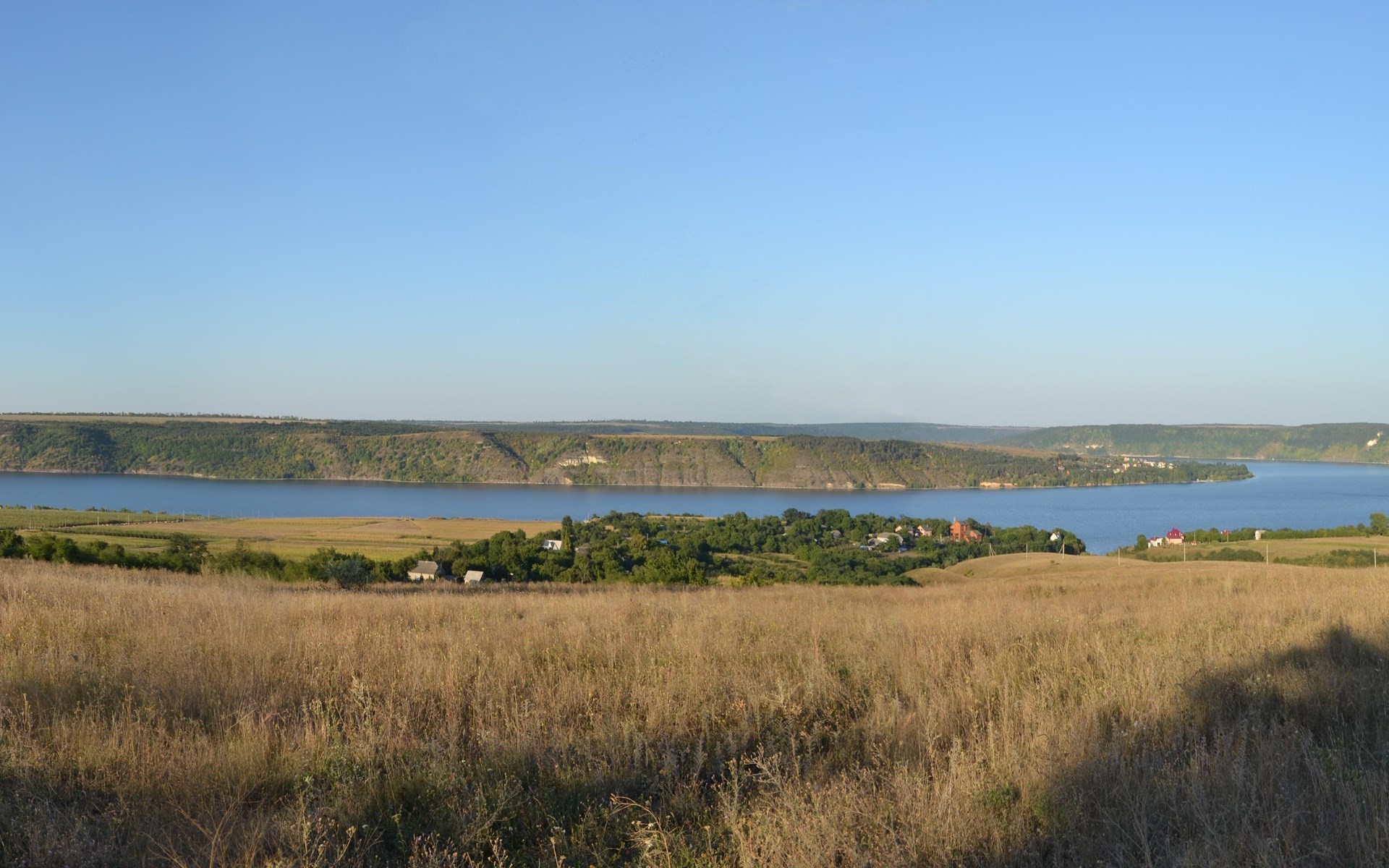 River landscape with hills and a village HD Wallpaper