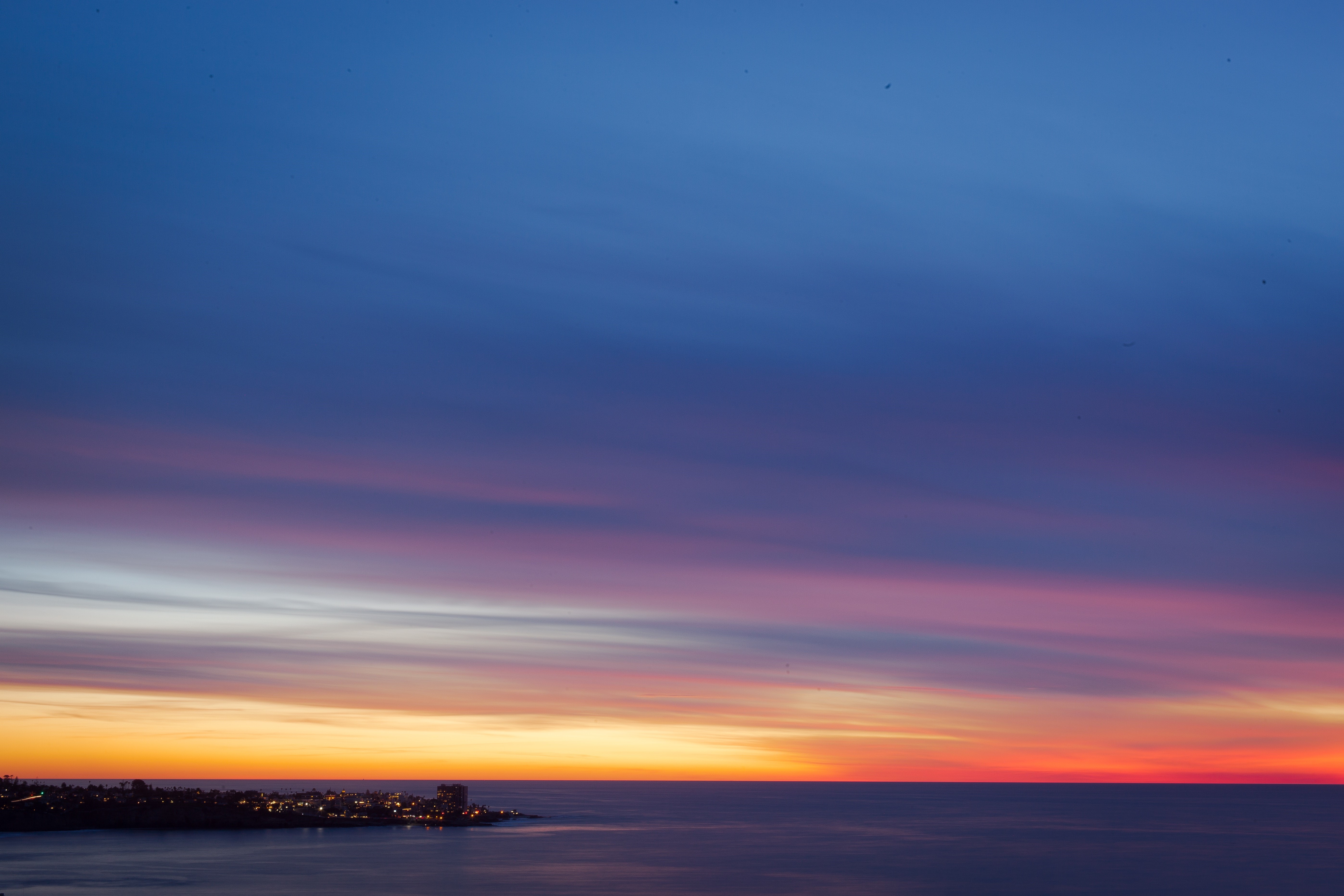 Sunset over a coastal city HD Wallpaper