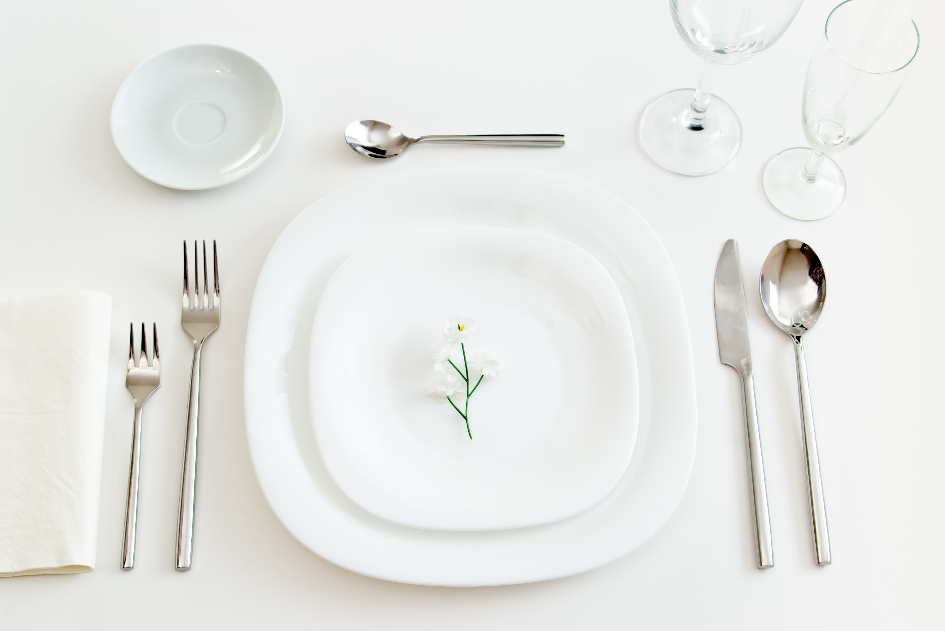 Table setting with plates, cutlery, glasses, and a flower HD Wallpaper