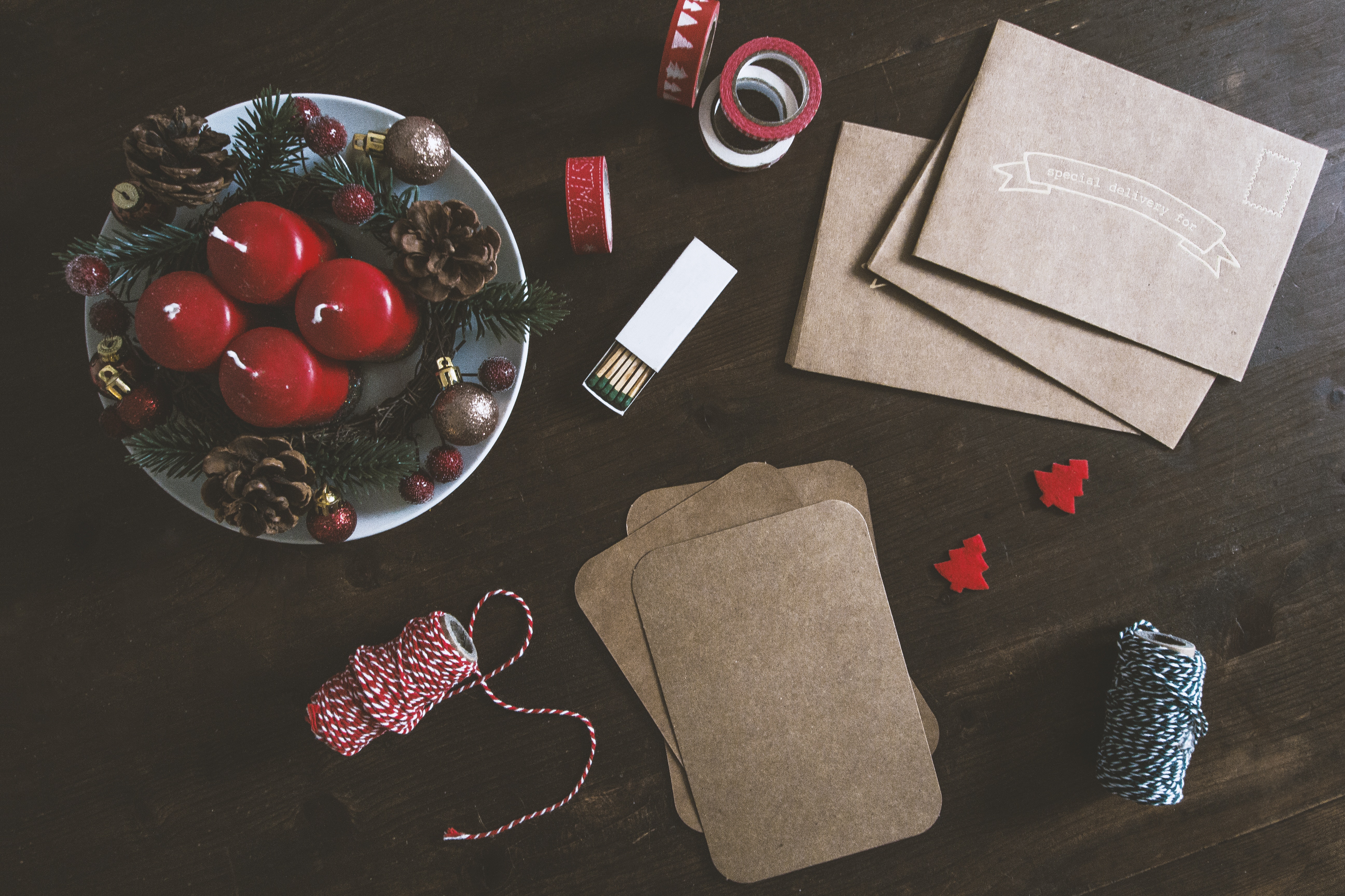 Christmas flatlay with red candles, pinecones, and craft supplies HD Wallpaper