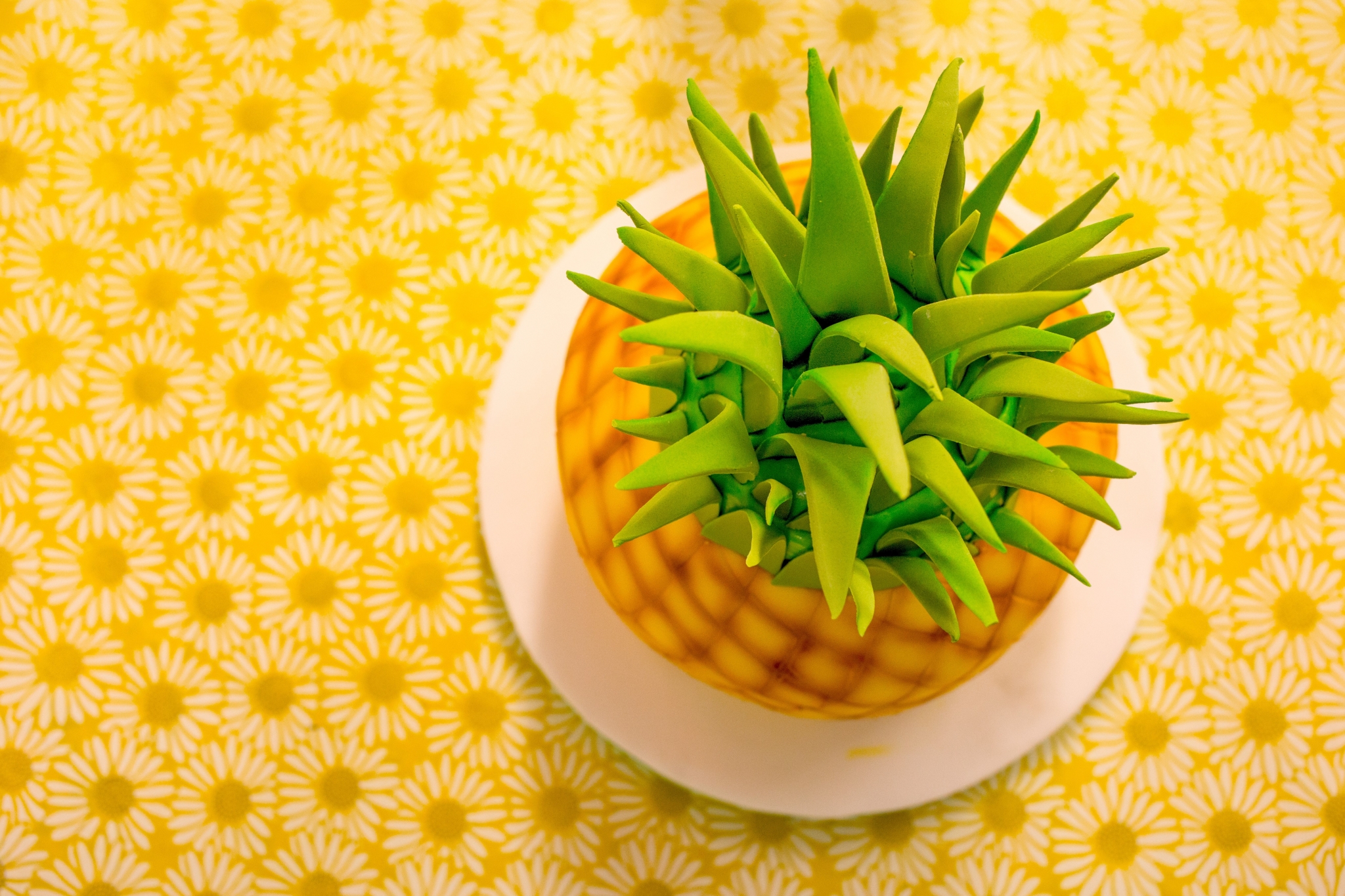 Pineapple cake on a yellow floral tablecloth HD Wallpaper