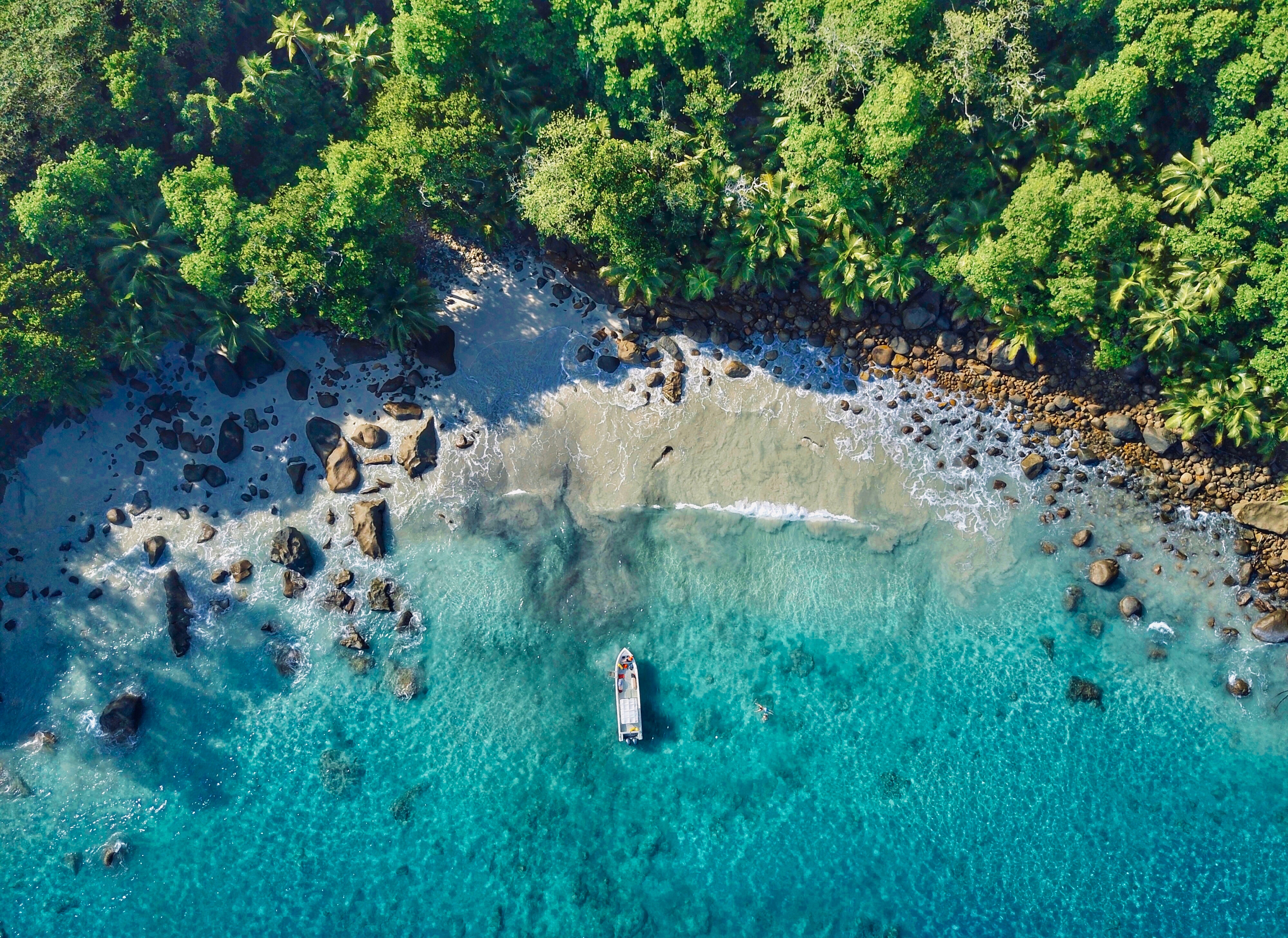 Aerial view of a tropical beach in Seychelles with a boat HD Wallpaper