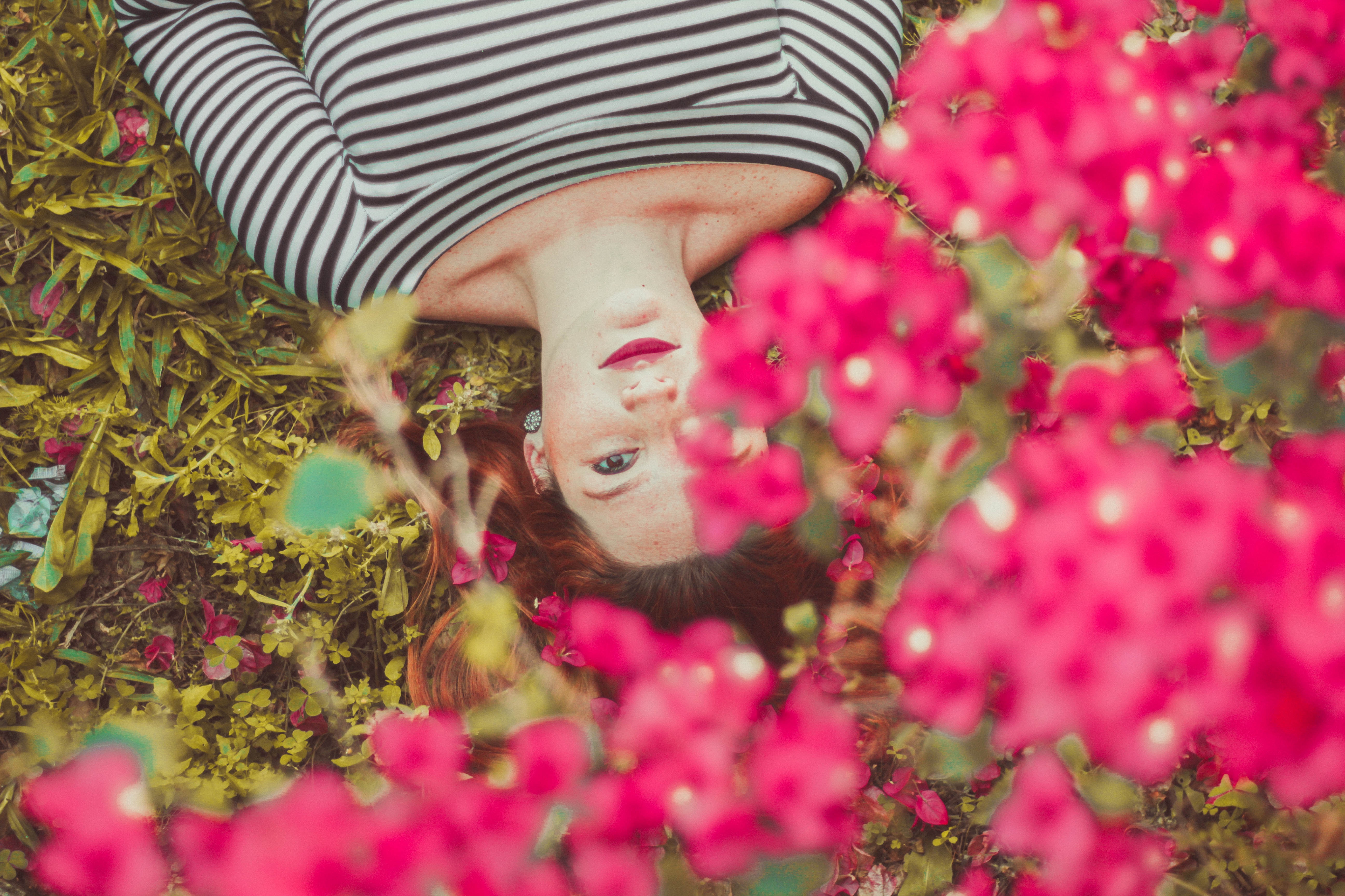 Woman lying on grass with pink flowers HD Wallpaper